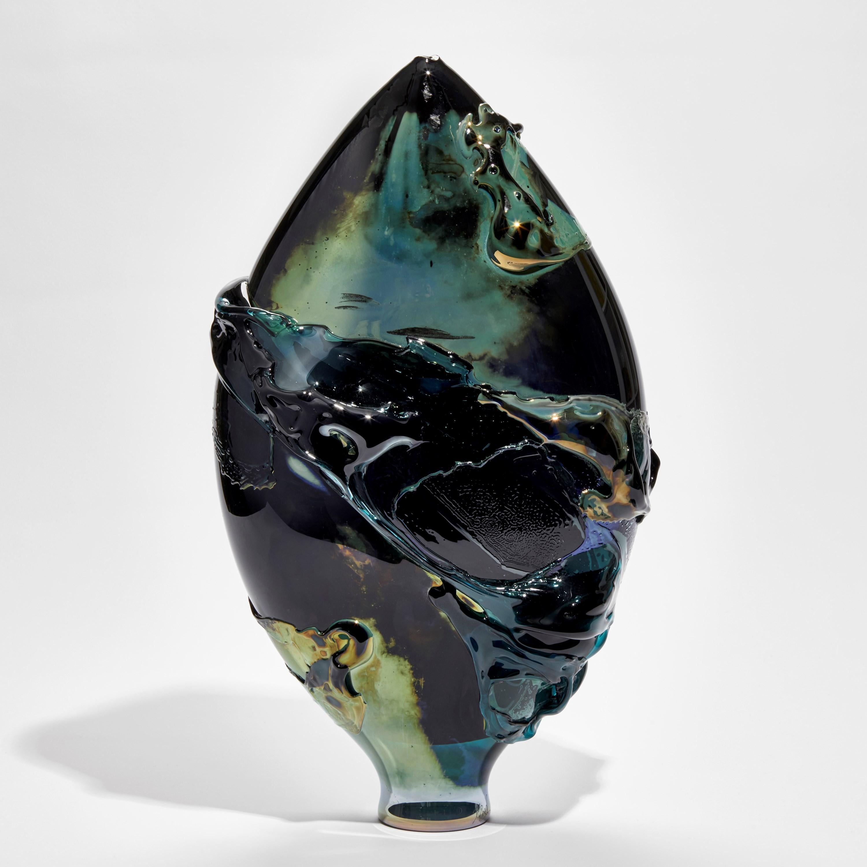 Black Sea II is a unique black, sea green and aqua sculptural glass vessel with a lustrous metallic finish by the British artist, Bethany Wood. An equal passion for painting physically inspires how she controls and manipulates her glass. Recreating