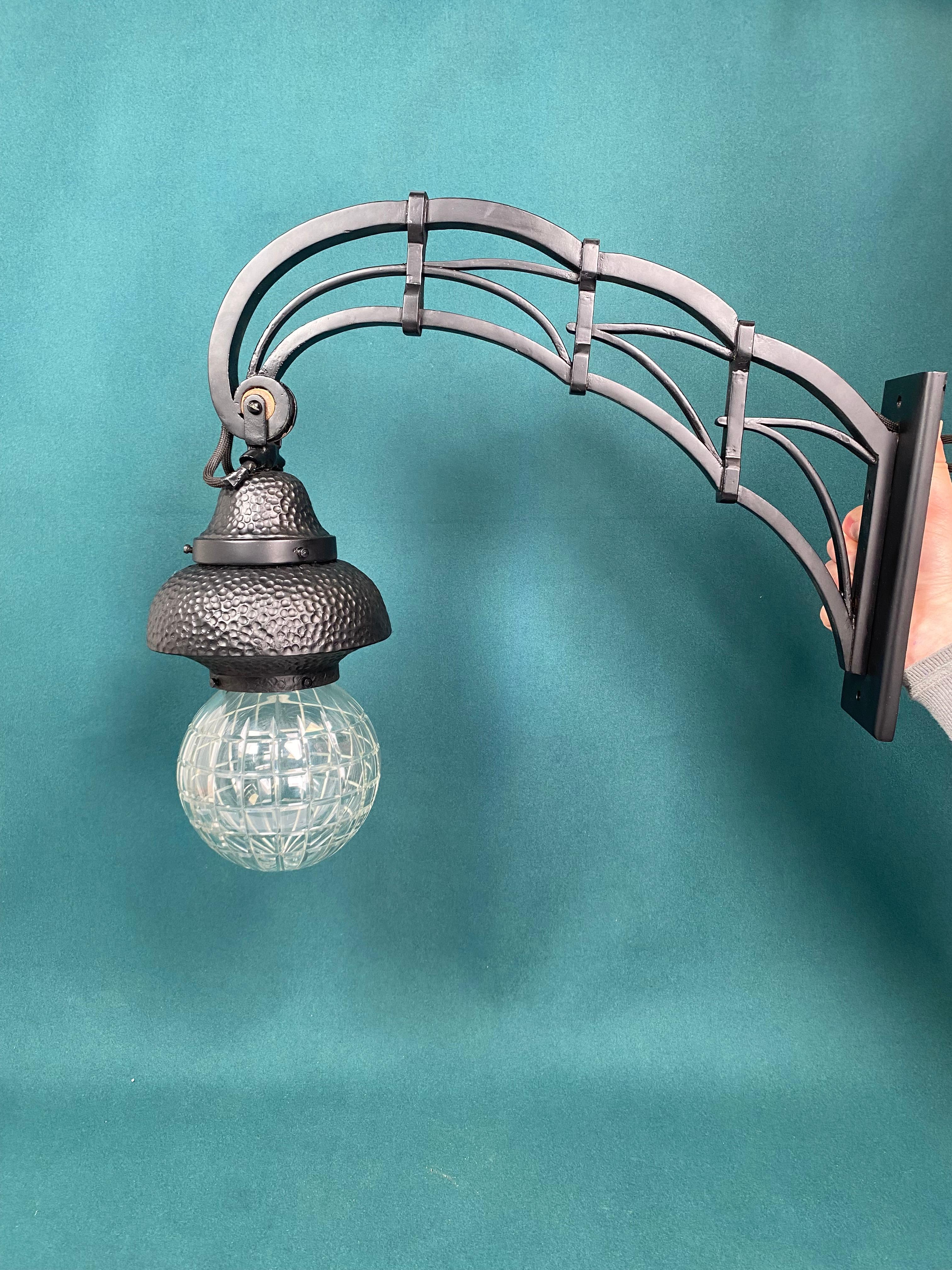 Lampada da parete secession nera con decoro martellato e paralume a globo in vetro. Colorato e riverniciato professionalmente, fili nuovi.