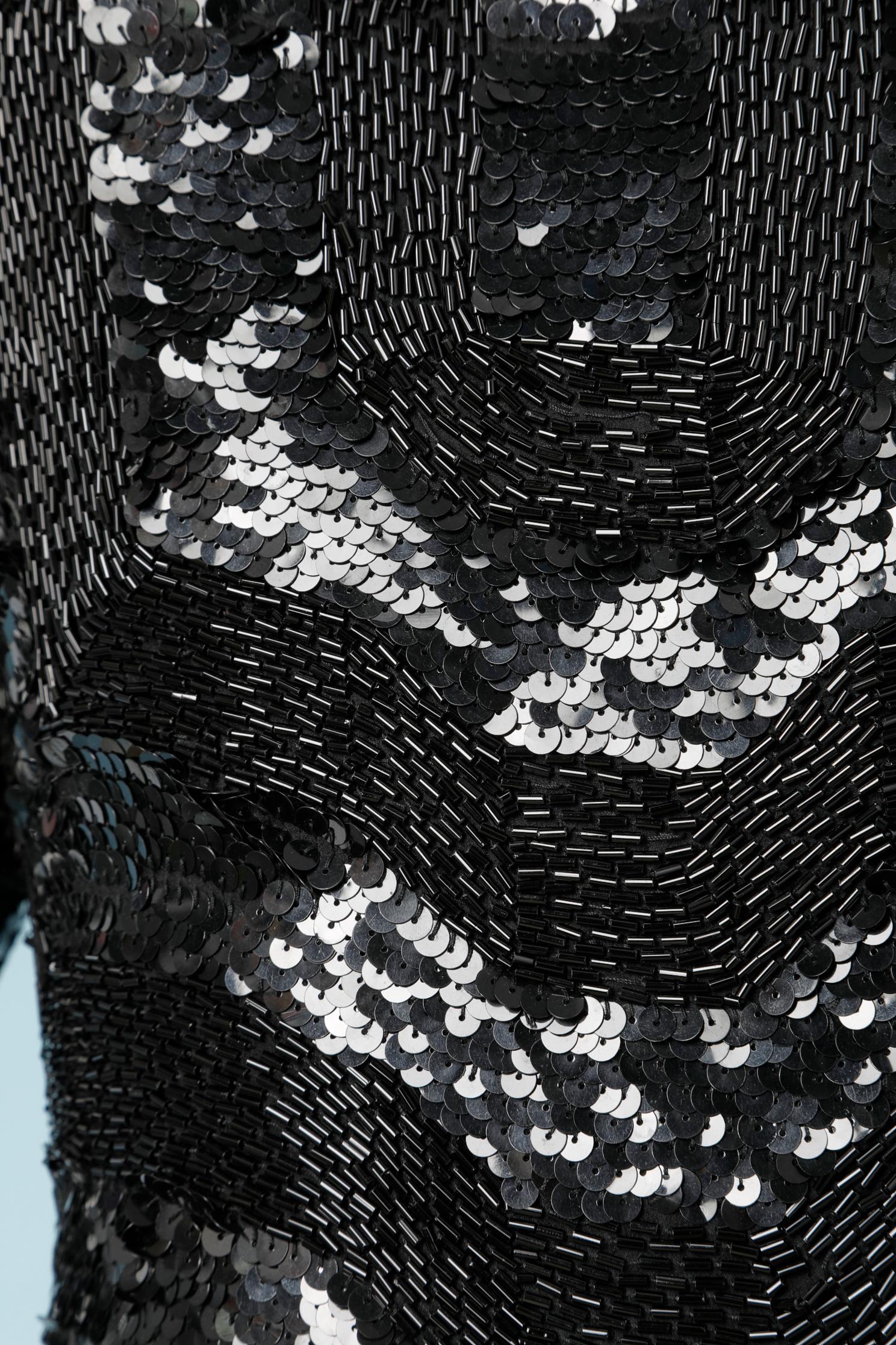 Schwarzes, mit Pailletten und Perlen besetztes Cocktailkleid mit schwarzem Seidenfutter. Reißverschluss und Schlitz (Länge 35 cm) auf der rechten Seite 
GRÖSSE M 