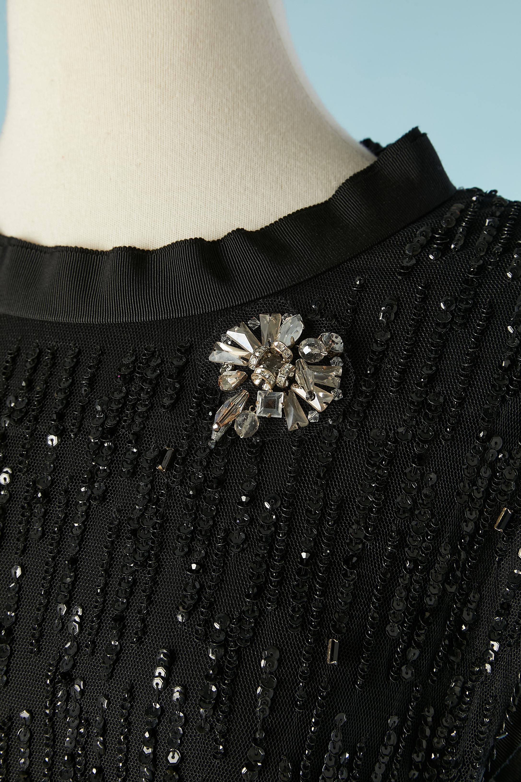 Black sequin dress on a tulle base with rhinestone brooches. Collar, armhole and bottom edge in black gros-grain.
Fabric composition: 
Main fabric: 95% rayon, 5% silk. Lining: 100% polyamide.
Gros-grain: 100% rayon. Sequins: 100% polyvinyl chloride.
