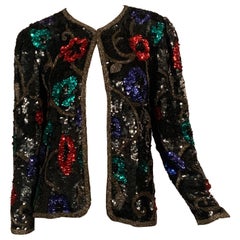 Chaqueta de lentejuelas negras con adornos de flores de colores y enredaderas