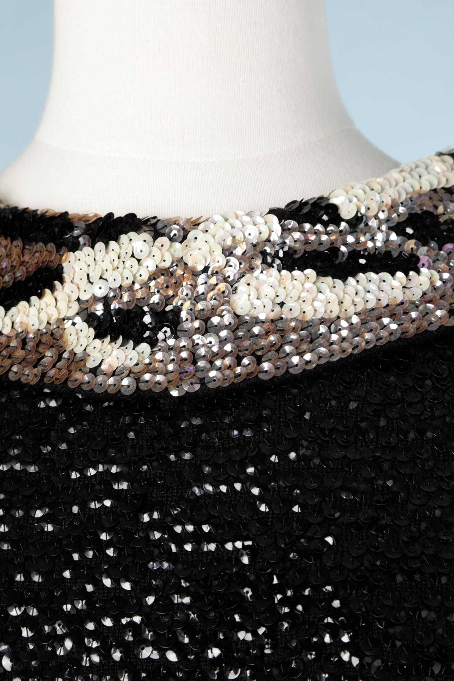 Top sans manches en paillettes noires avec col à motifs sur une base en tricot de laine. La composition de la doublure est probablement de l'acétate ou de la rayonne. Fermeture à glissière au milieu du dos.
TAILLE 44 / L. 