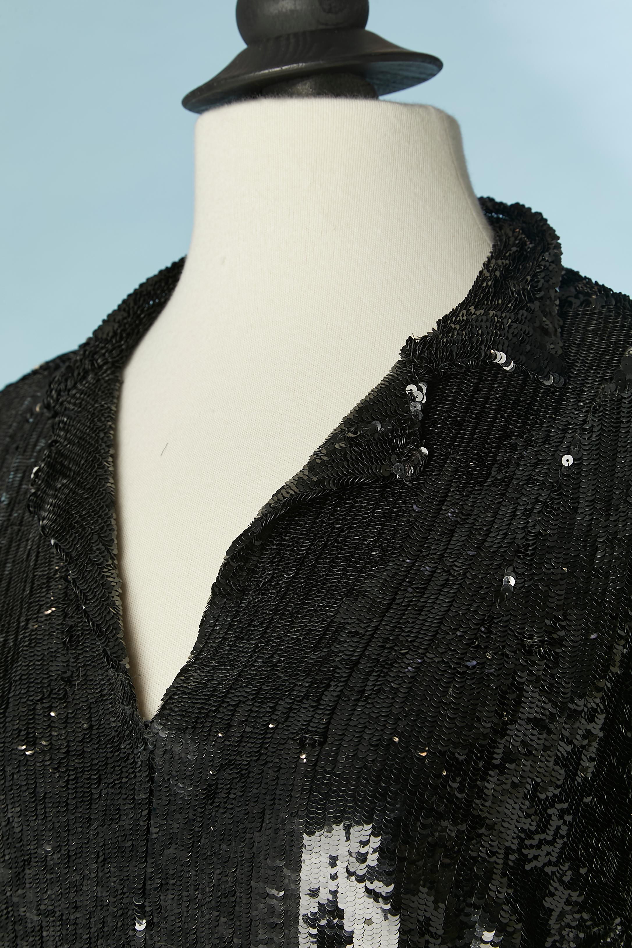 Top en paillettes noires sur une base de tulle avec col. 
Fermeture à glissière sur le côté gauche. Découpe à la taille. 
TAILLE 38/40 M 