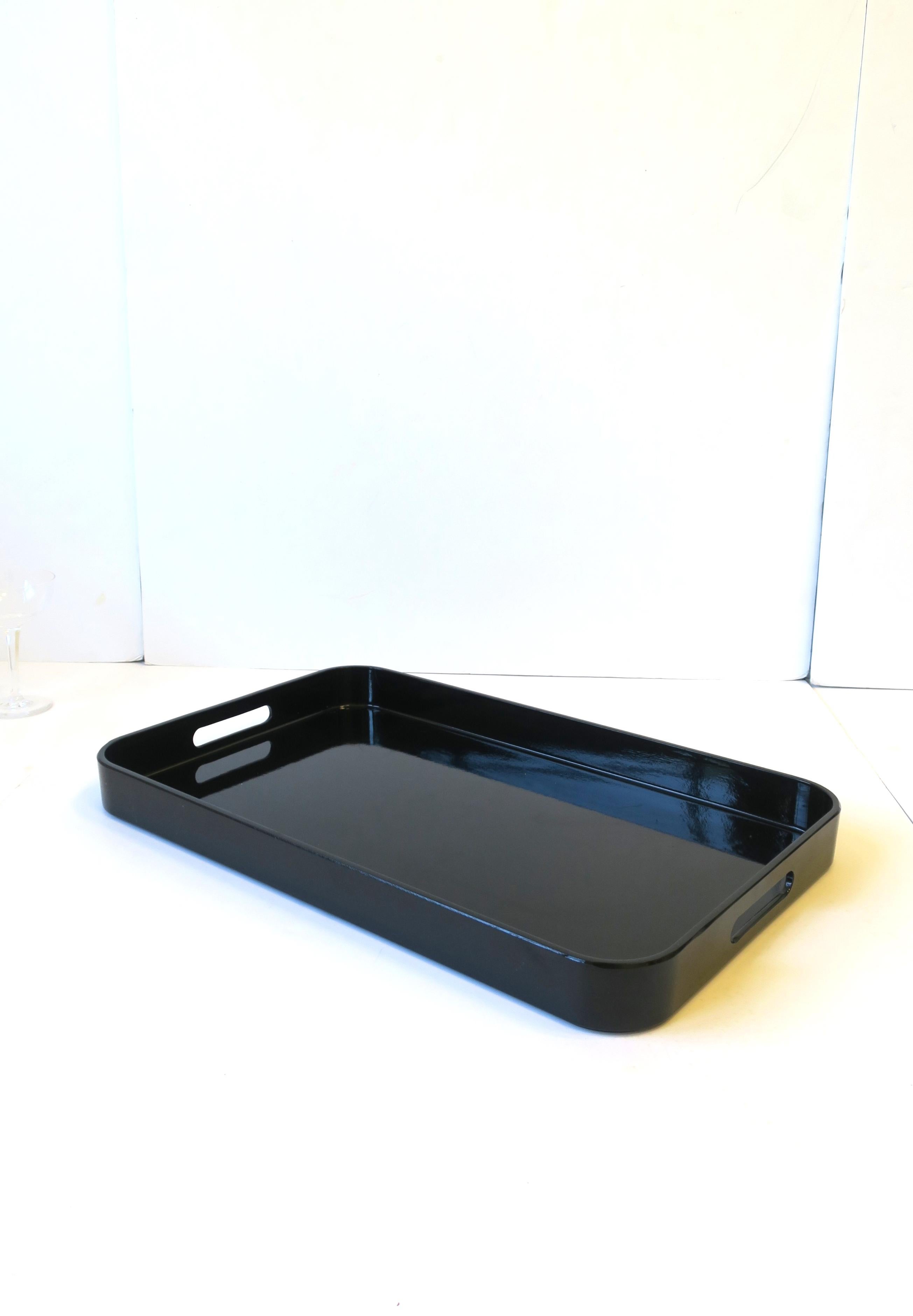 A modern style black lacquer style serving tray, circa late-20th century. Tray has rounded corners and cut-out handles. A great tray for serving or storing/displaying. Tray is a nice size. 

Dimensions: 13.5