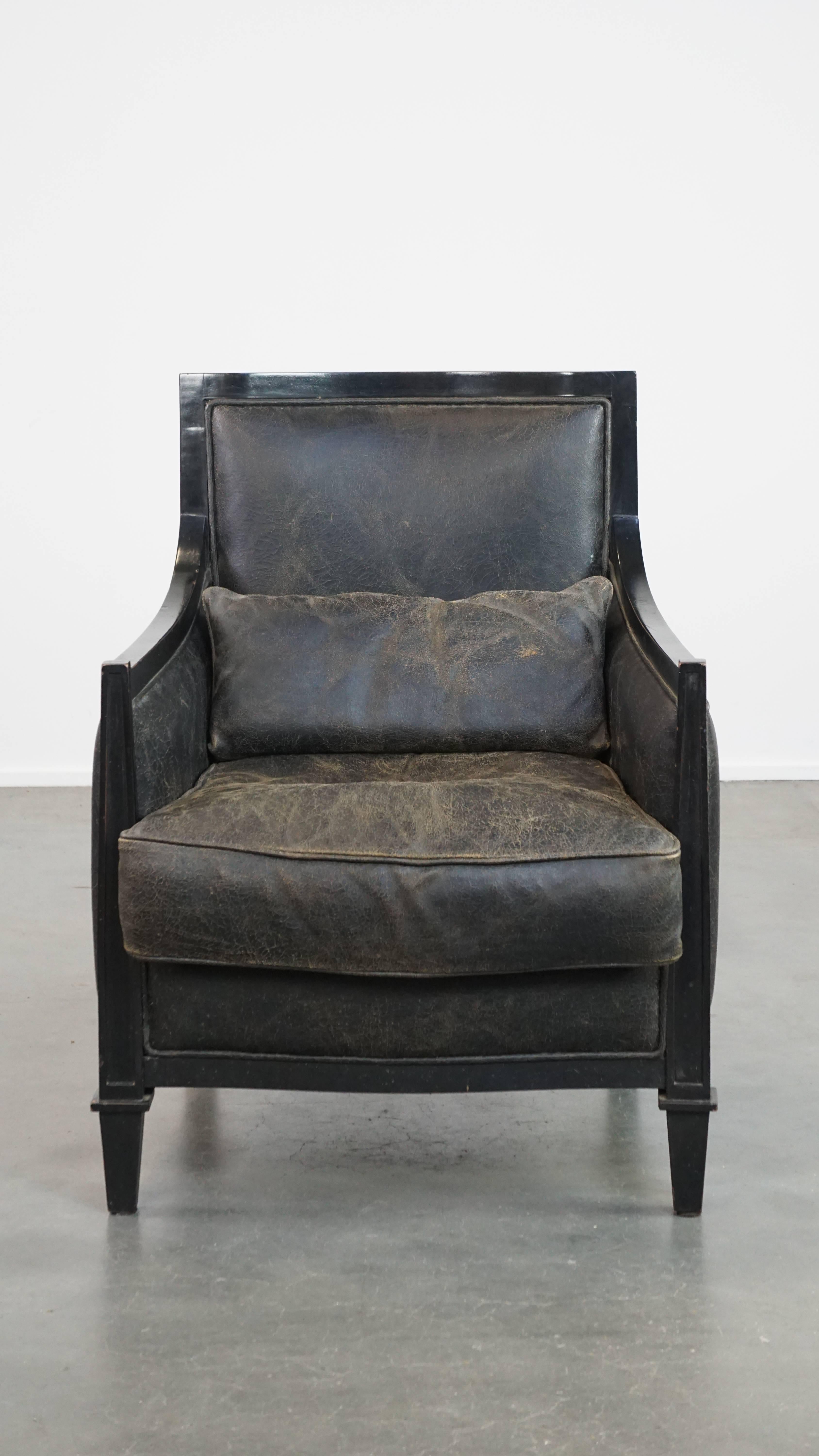 Packed with character, this unique cowhide leather armchair also exudes the timeless luxury and charm of Art Deco design. Its deep black color, combination with wood and sleek finish enhance this character. This armchair comes with a separate seat