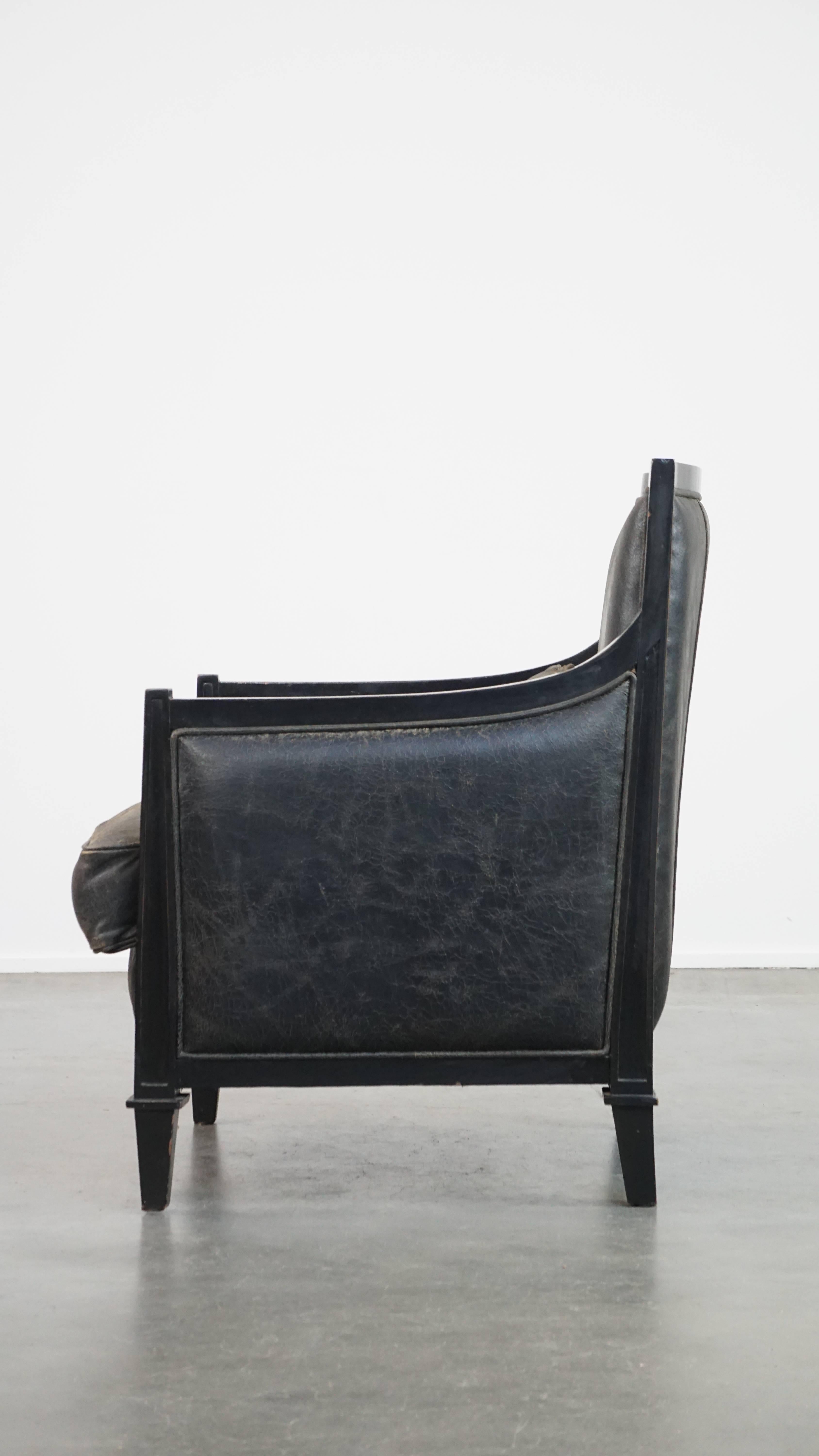 20th Century Black cowhide leather and wooden armchair with a timeless Art Deco design For Sale