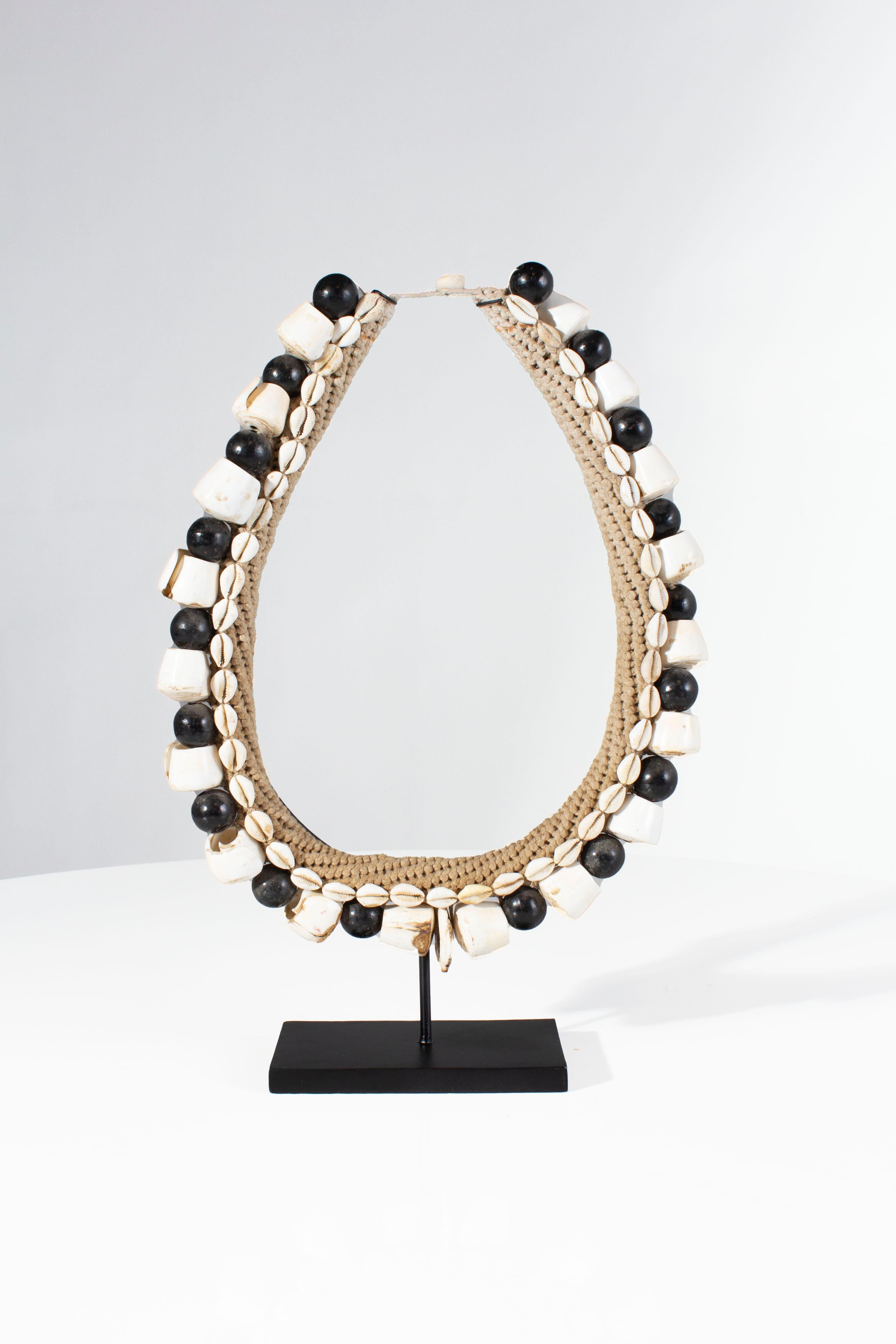 Black shell necklace accessory on metal stand.

One of a kind sourced from Belgium.

2 available.