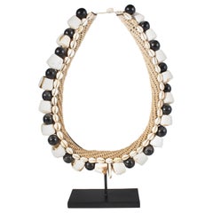 Accessoire pour collier de coquillages noirs sur support