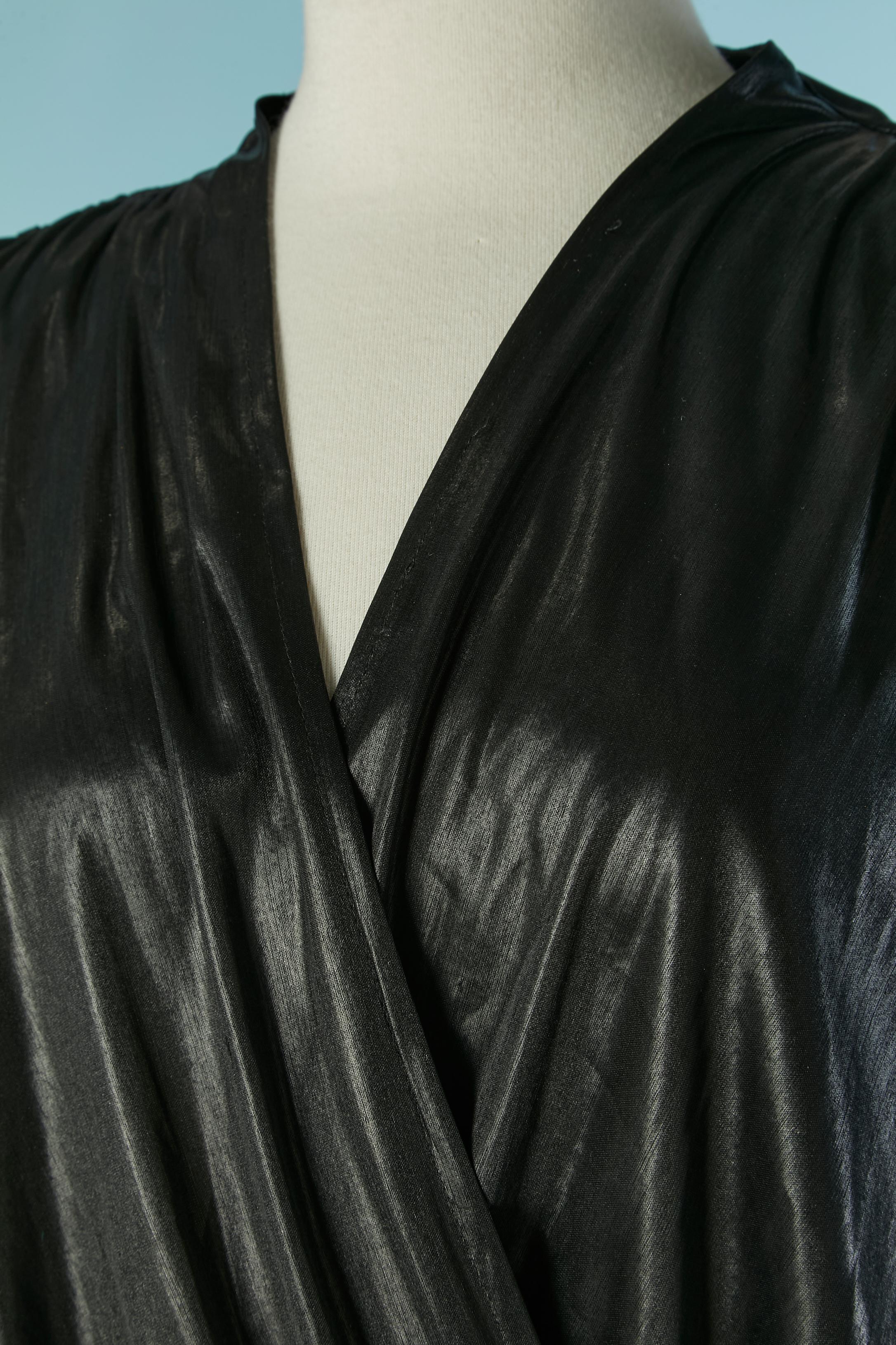 Schwarzes Abendkleid aus glänzendem Polyester-Jersey. Am Ärmel entlang zusammenfassen. Oben einwickeln. Gummiband in der Taille. Spalt unten links, Länge = 30cm
Dünnes Shoulder pad. 
GRÖSSE 44 / L 