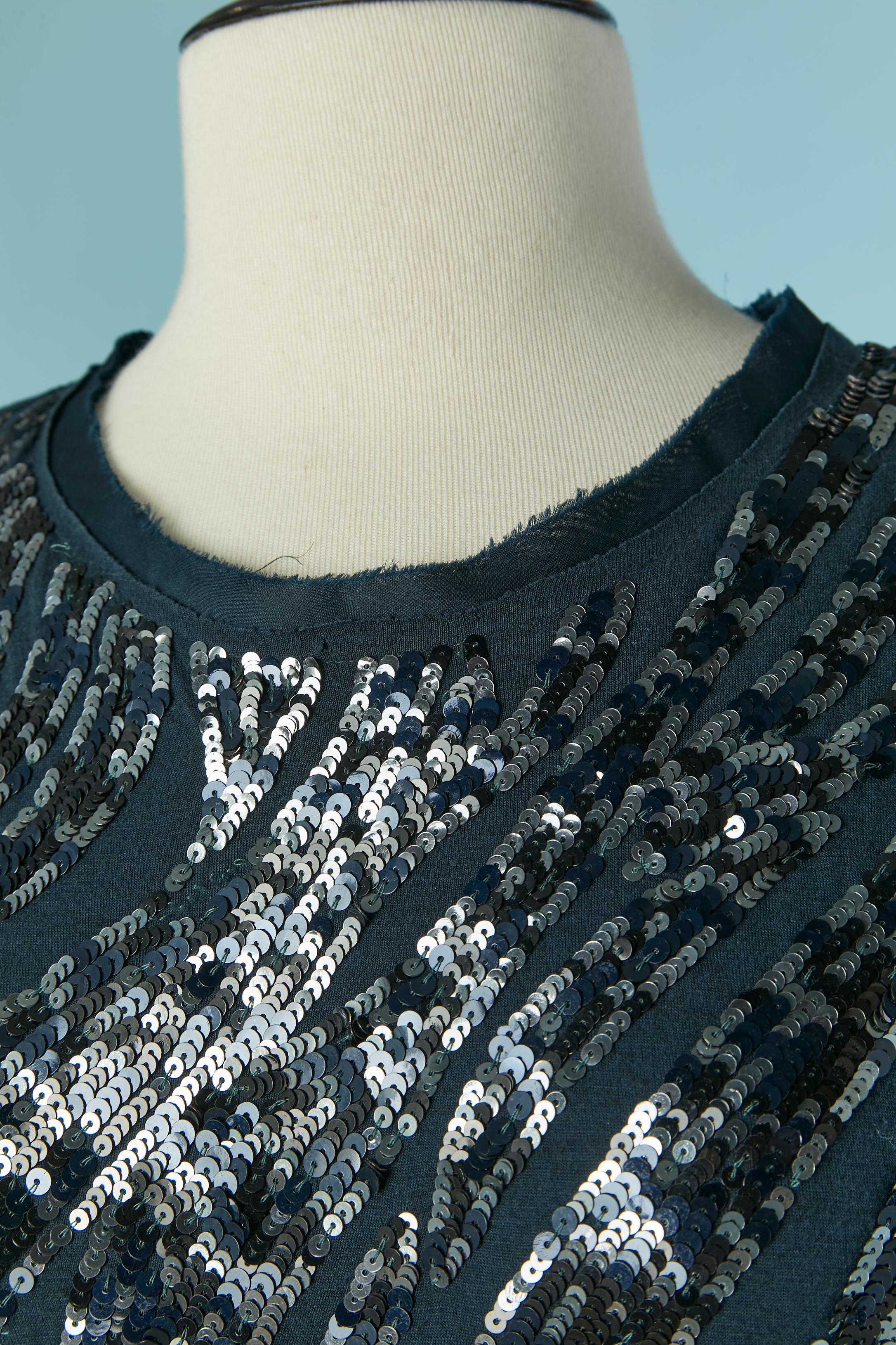 Robe de cocktail drapée à paillettes noires sur base de jersey bleu. Fermeture à glissière au milieu du dos. Drapée sur les hanches gauches. 
TAILLE L 