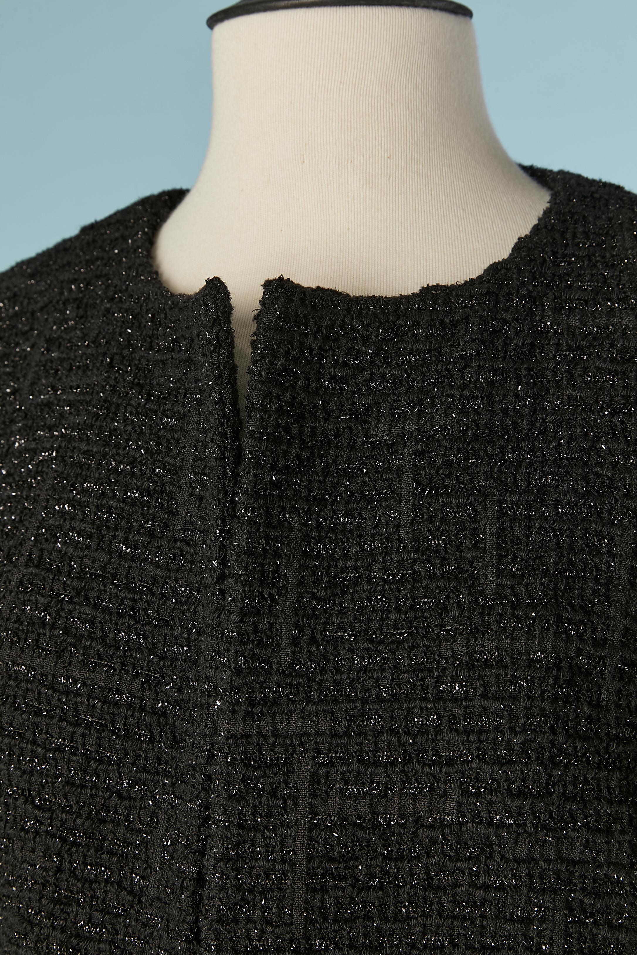 Cappotto in tweed nero lucido (lana e lurex) da un bordo all'altro. Fodera in seta nera. Tasca su entrambi i lati. 
TAGLIA L 