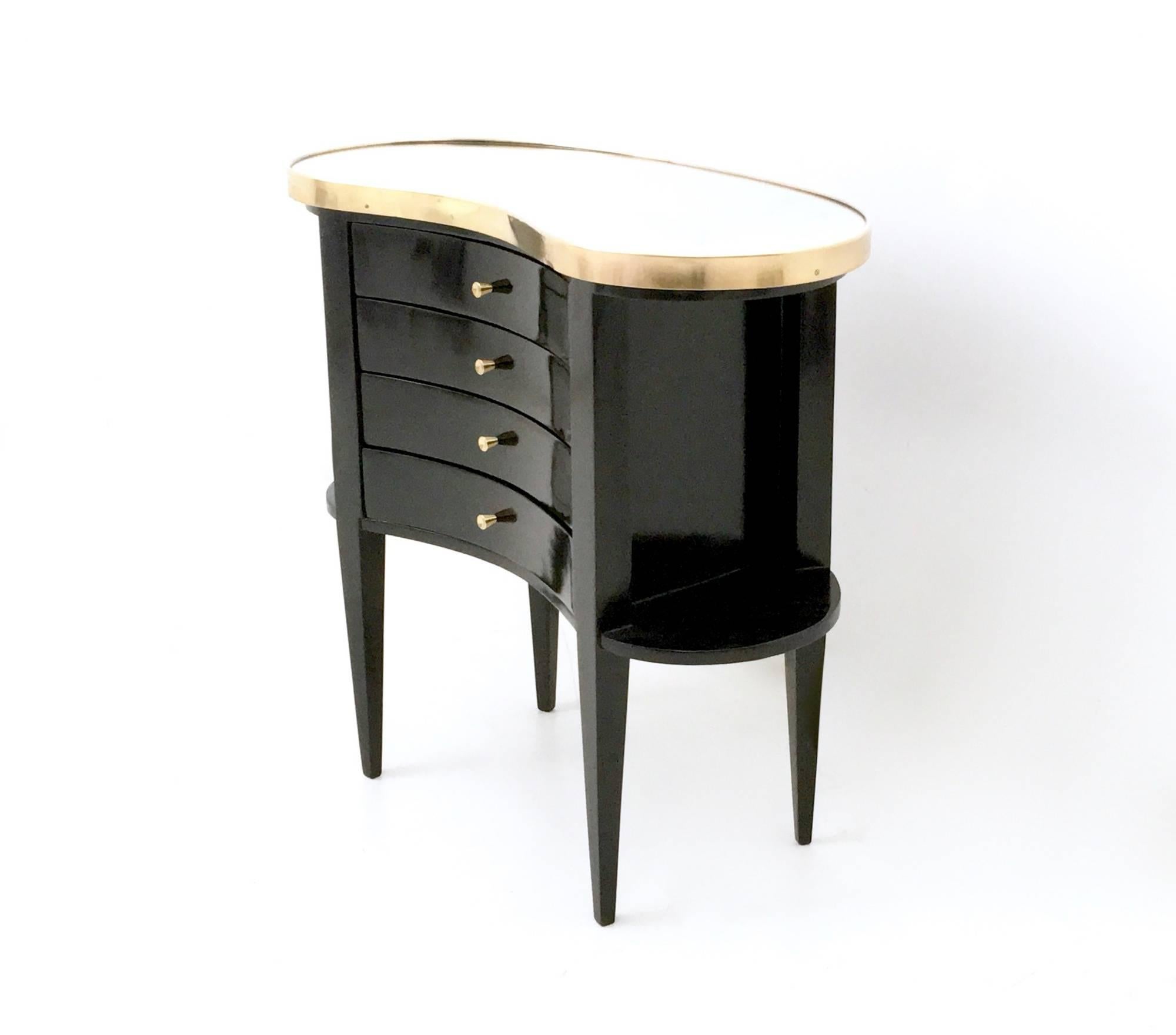 It is made in black lacquered wood and features a mirrored glass top, which is framed by brass.
The top has two slight traces of oxidation. 
It has been restored and it is in such perfect condition that it's ready to become a piece in a home.