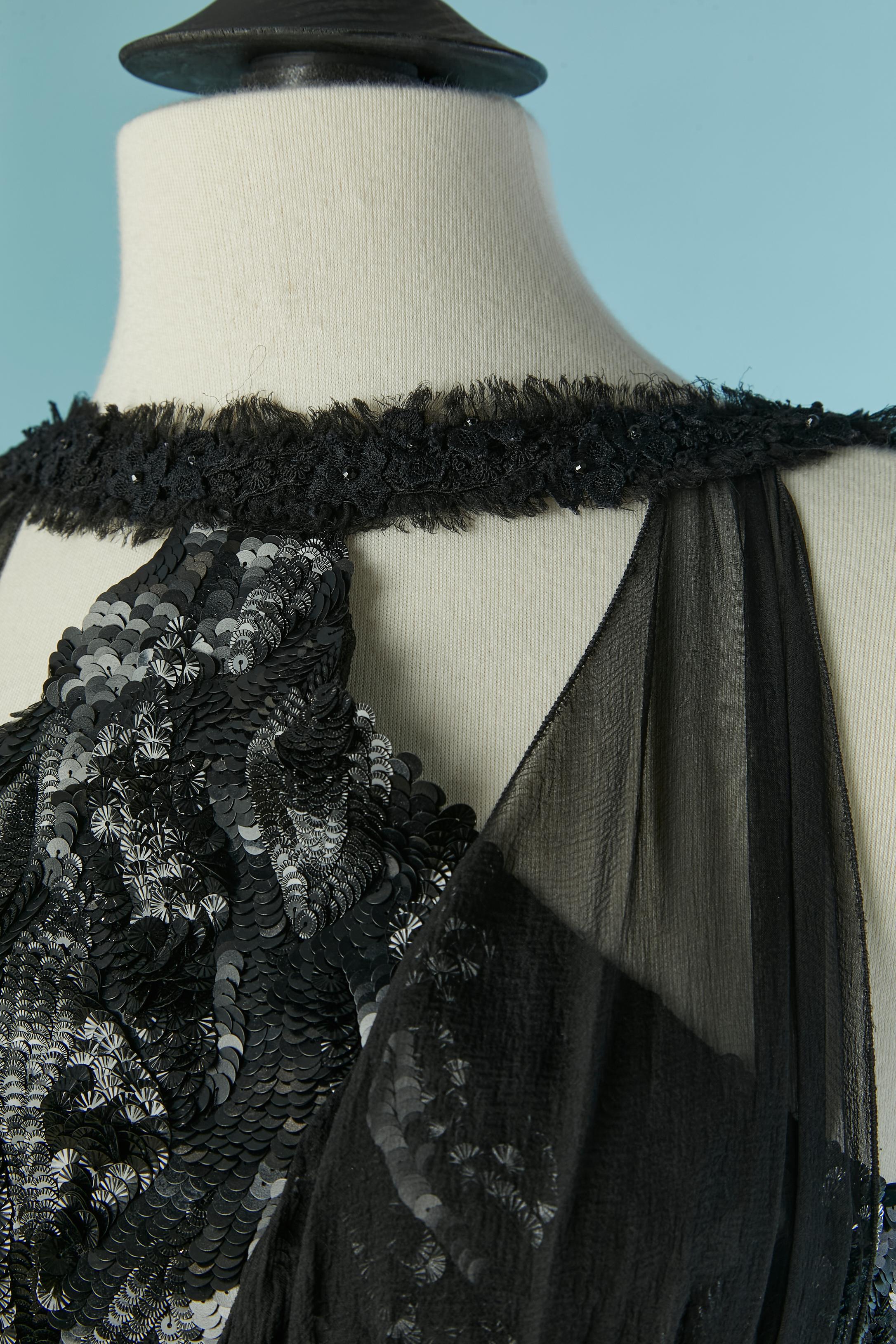 Abito da sera asimmetrico in chiffon di seta nero con ricamo di paillettes. La parte inferiore è composta da 3 strati: uno in chiffon di seta, uno in morbido tulle e uno in seta. Chiusura con zip invisibile al centro della schiena + bottone