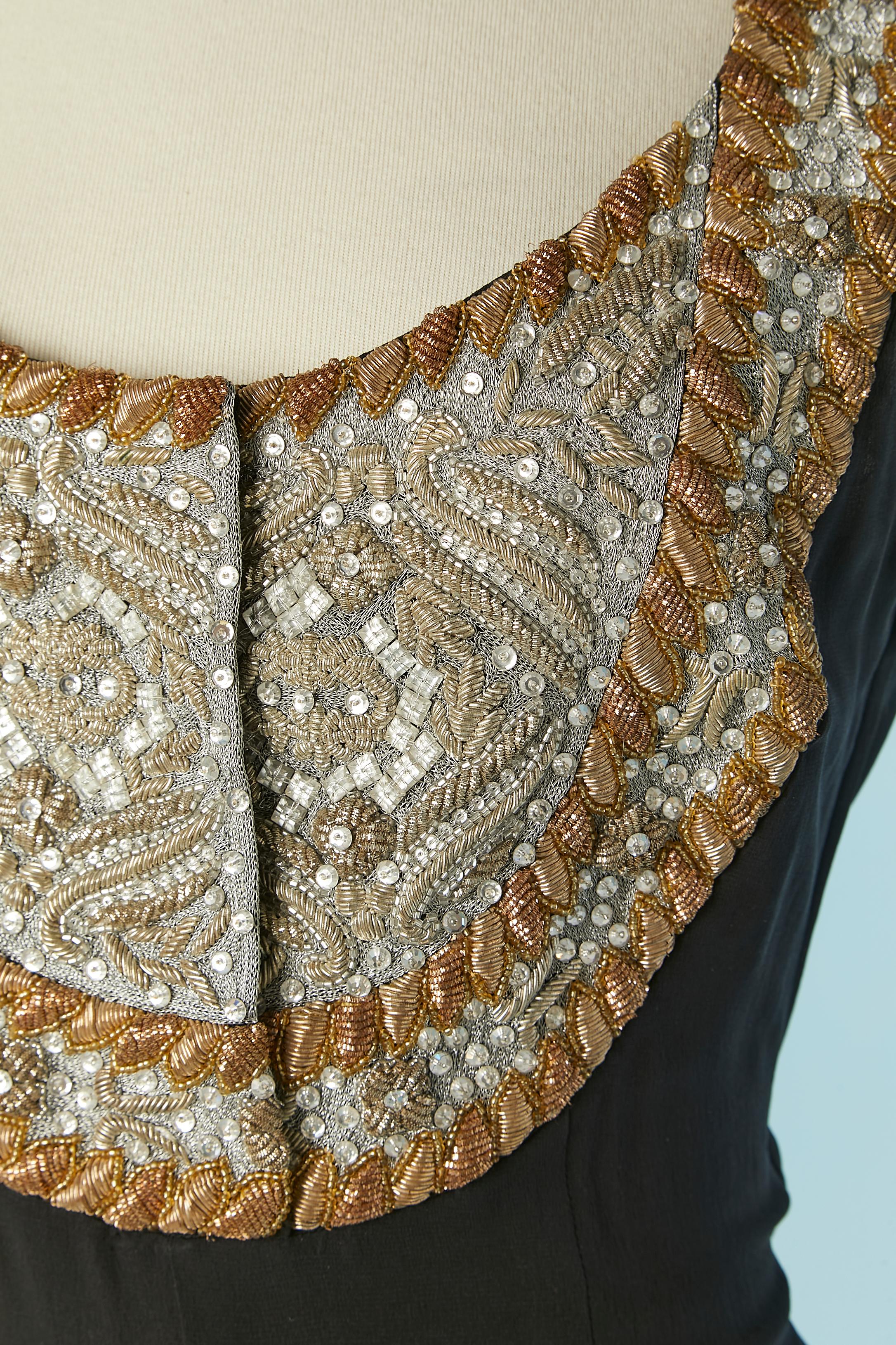Schwarzer Seiden-Jumpsuit mit Plastron mit Gold- und Silberfaden-Stickereien + Perlenstickerei. Druckknopfverschluss in der Mitte der Vorderseite und Reißverschluss auf der linken Seite der Büste. 
Taschen auf beiden Seiten. 
SIZE 38( Fr) 6 (Us) M 