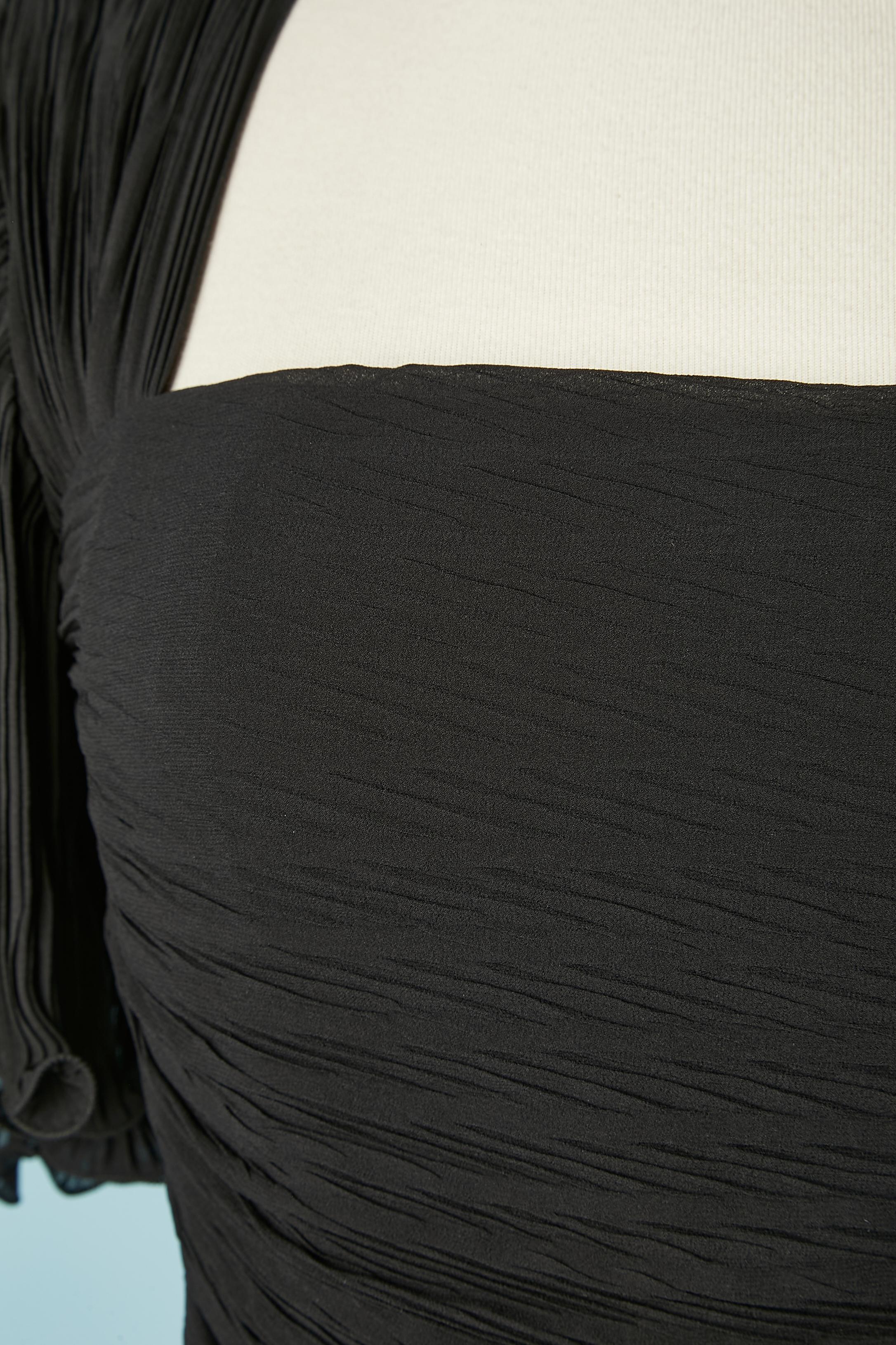 Robe de cocktail plissée en soie noire avec volants. Doublure en organza à l'intérieur des manches et doublure en rayonne à l'intérieur de la robe. Epaulières
TAILLE S