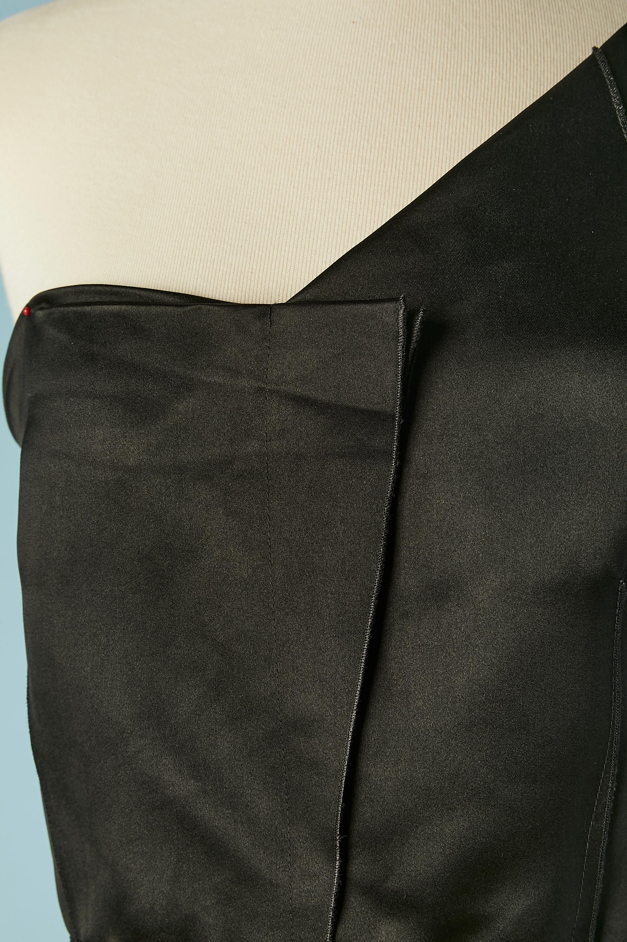 Robe de cocktail à une épaule en satin de soie noir. Fermeture à glissière et un bouton pression au milieu du dos. Coutures extérieures . L'étroite bretelle sur l'épaule est une bretelle de soutien-gorge. Bande de taille en gros grain à l'intérieur
