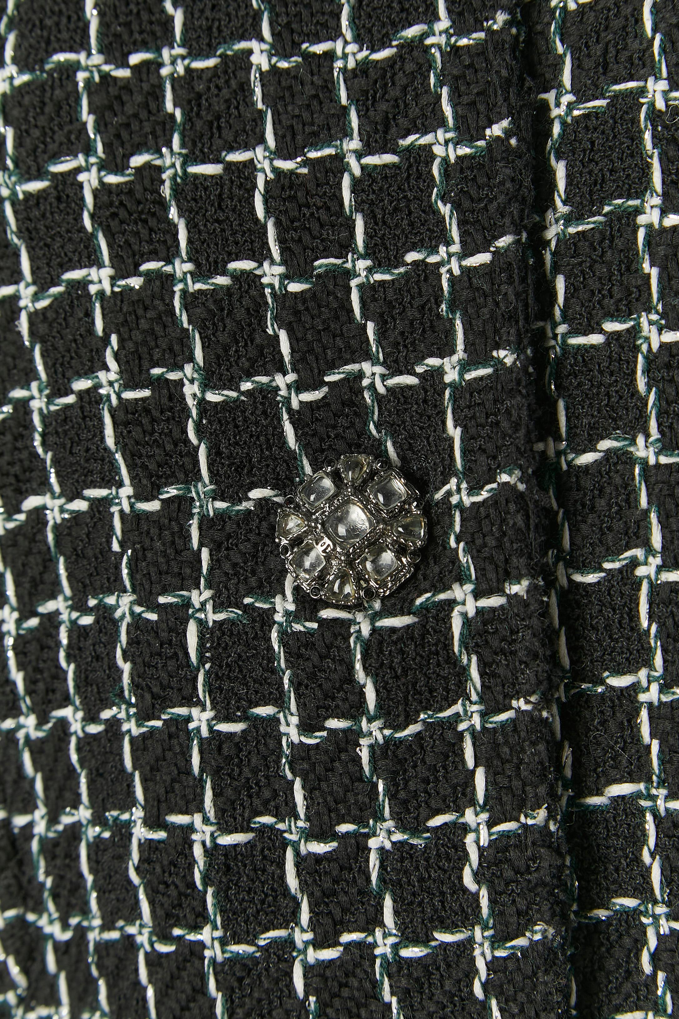 Giacca monopetto nera in tweed con motivo a quadri. Composizione del tessuto principale: 87% cotone, 10% lana, 3% poliestere. Fodera in seta con marchio. Catena all'interno della giacca sul bordo inferiore. Chiusura con bottoni gioiello e asole sul