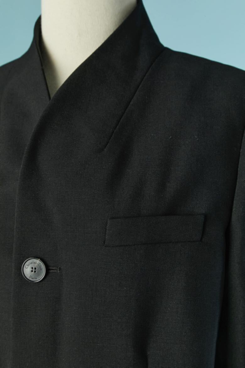 Veste simple noire . Pas d'étiquette de composition du tissu mais probablement de la laine et la doublure est probablement de la soie. Bouton et boutonnière marqués sur le milieu du devant et sur les poignets. Poche sur les deux côtés + une poche