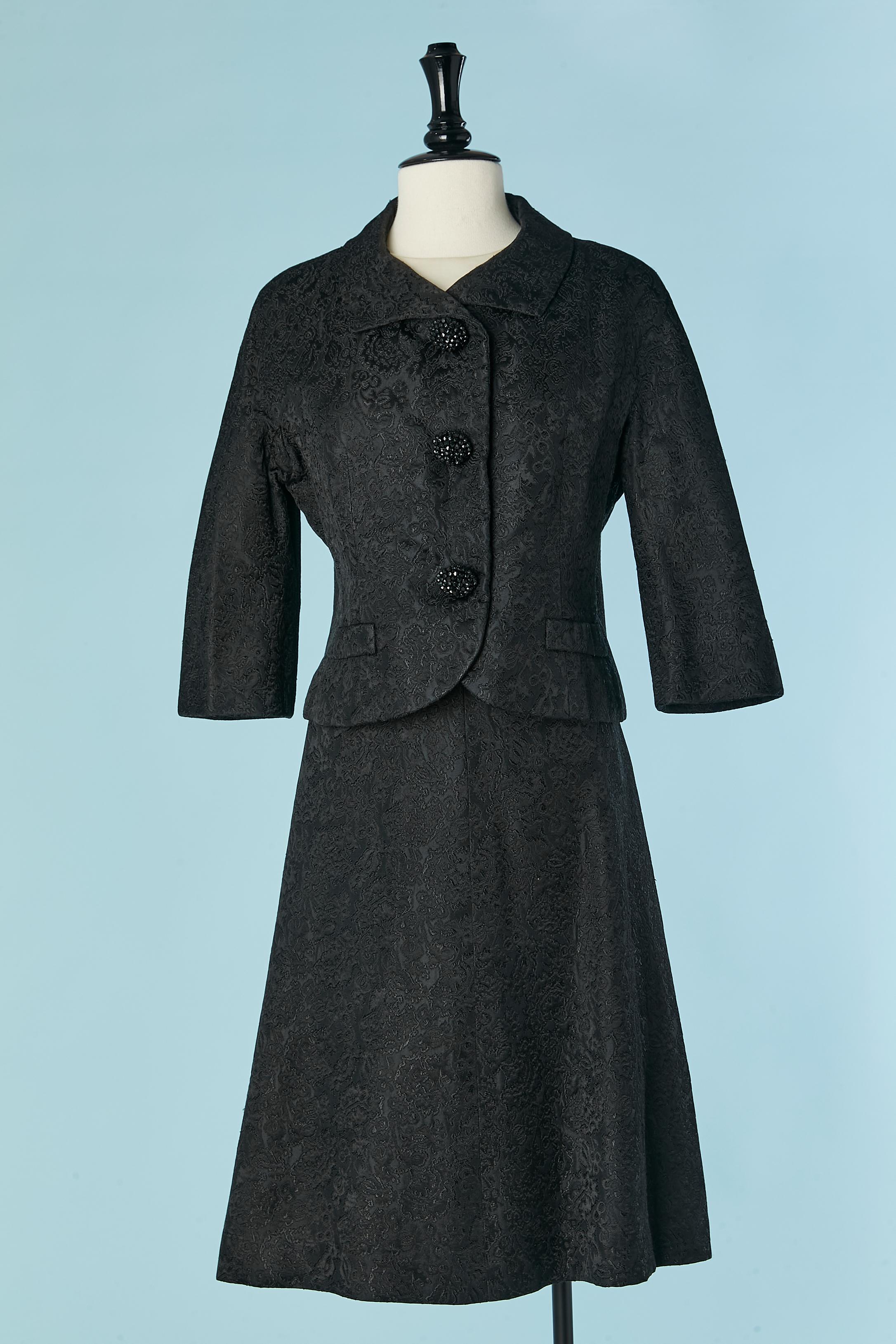 Black skirt suit and white ilk satin top ensemble . Christian Dior NY sold at William Penn Pittsburg
The jacket has raglan sleeves and snap closure on the top middle front with a decorative button on the top of the snap. Decorative pockets on both