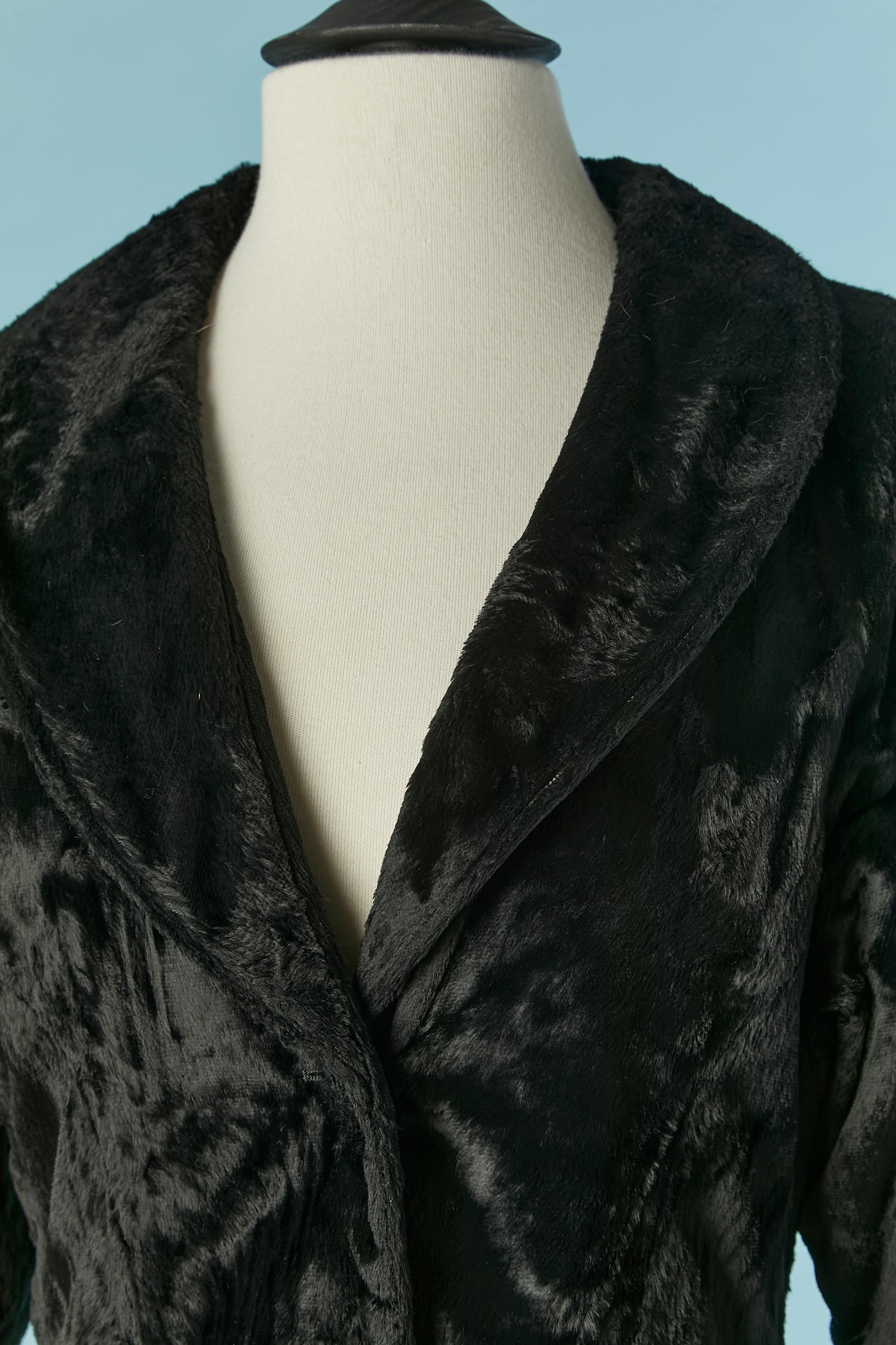 Black skirt-suit in velvet looking like faux fur. Main fabric composition:62% cotton 38% rayon. Lining composition: 64% acetate, 36% polyamide. Button covered in the same fabric and buttonhole closure on the middle front. Shoulder pad. Pocket on