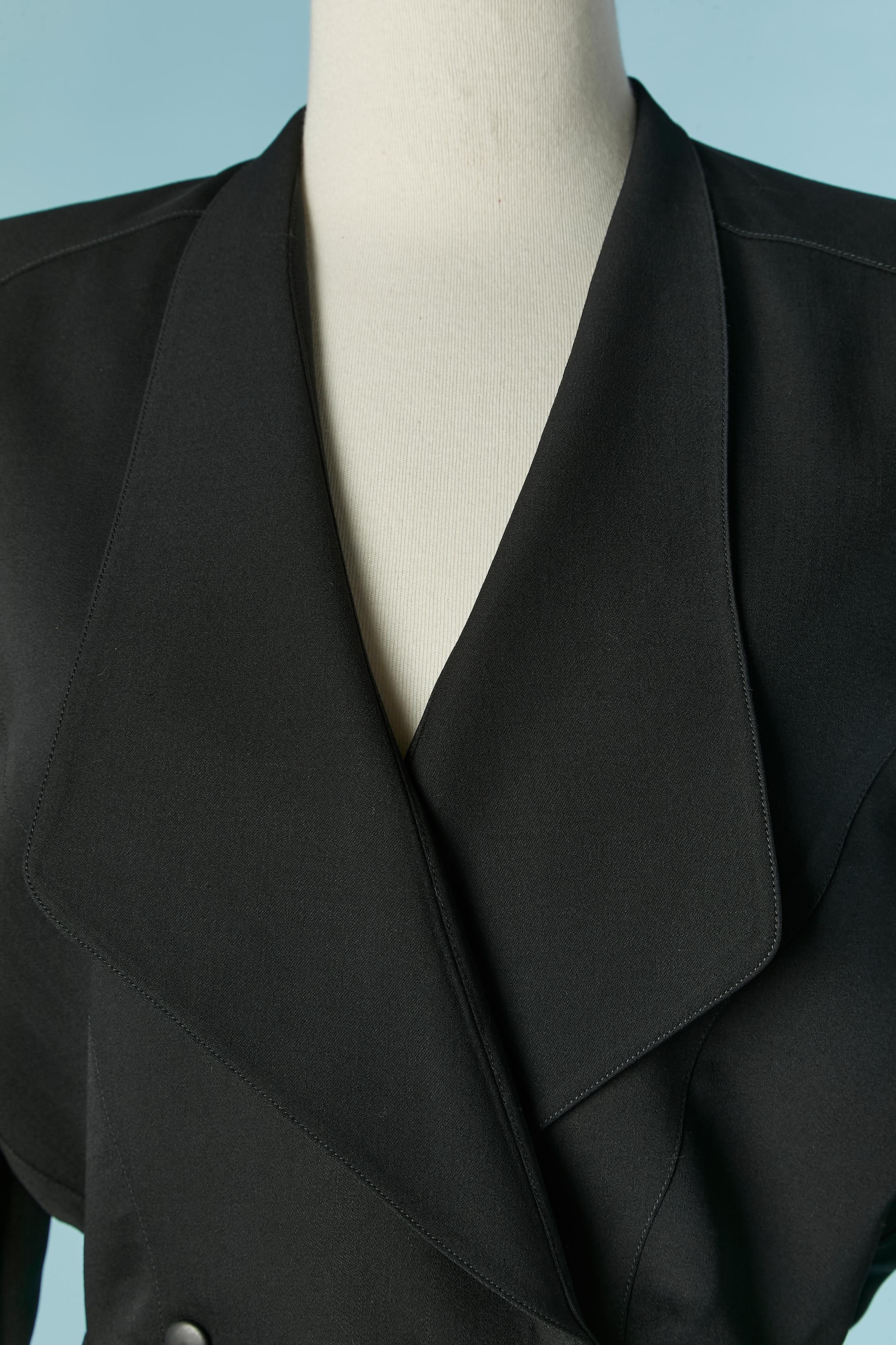 Black skirt-suit with double-breasted jacket . Shell fabric composition: 96% wool, 4% nylon. No indication for lining but probably acetate or rayon. 
Snap closure on the middle front. Shoulder-pad. Cut-work. Raglan sleeve.
SIZE 42 on tag but fit M/L