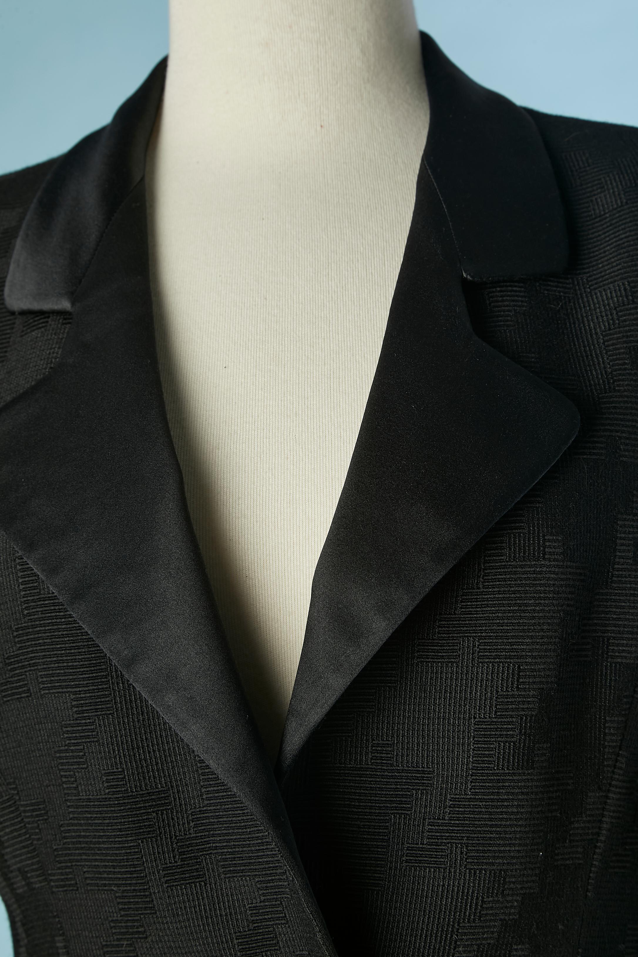 Schwarzer Rock-Anzug mit grafischem Muster. Kein Stoff Tag Zusammensetzung aber wahrscheinlich Wolle und Futter ist wahrscheinlich in Satin. Satin-Kragen. Schulter-Pad. Knöpfe mit Stoffbezug in der vorderen Mitte.
Größe M (Jacke) und S (Rock) 