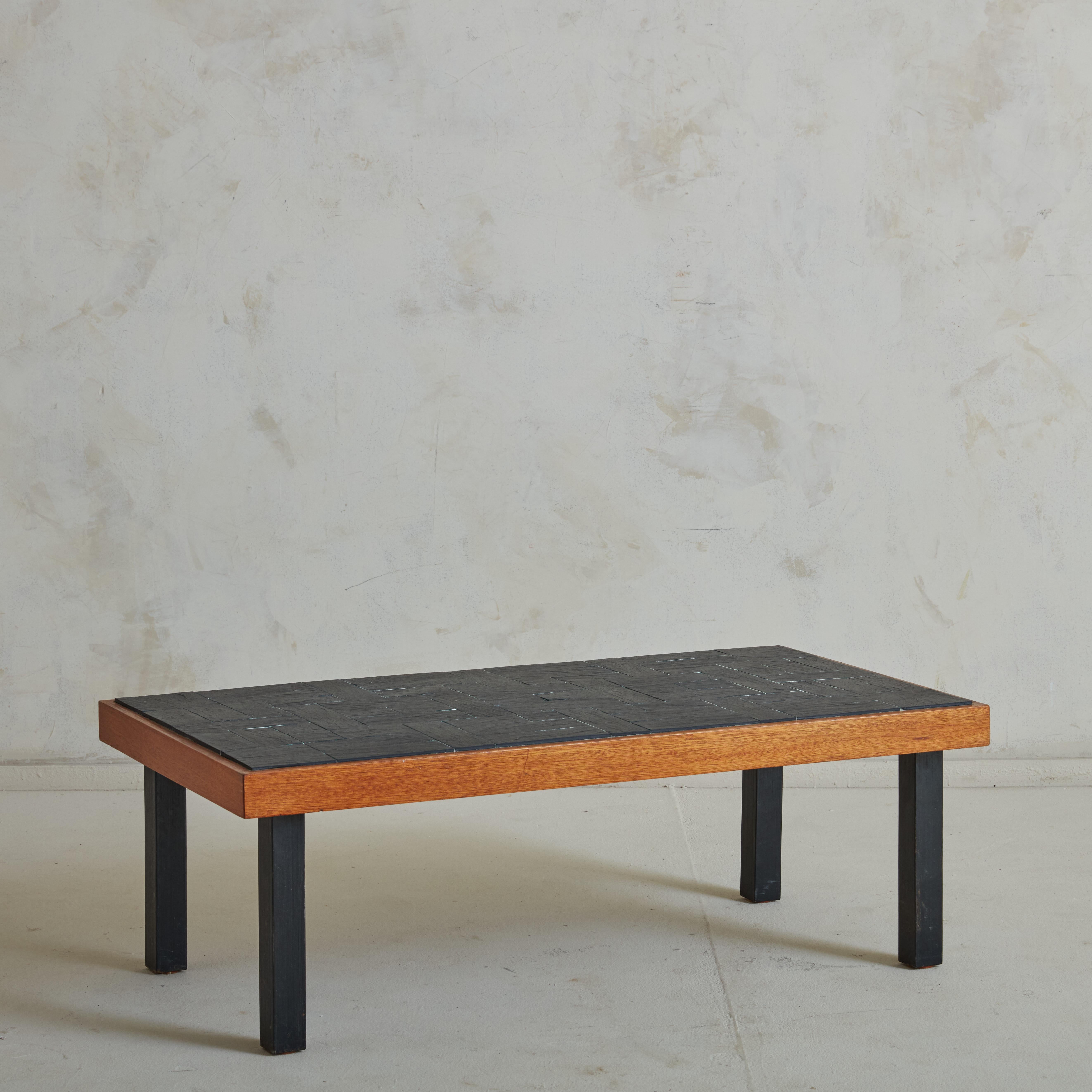 A vintage coffee table featuring an elm wood frame and slate tile top with painted wood legs. This design correlated heavily with Pierre Chapo’s collaboration with Maison Regain, which featured a slate tile elm wood coffee table. This table is a