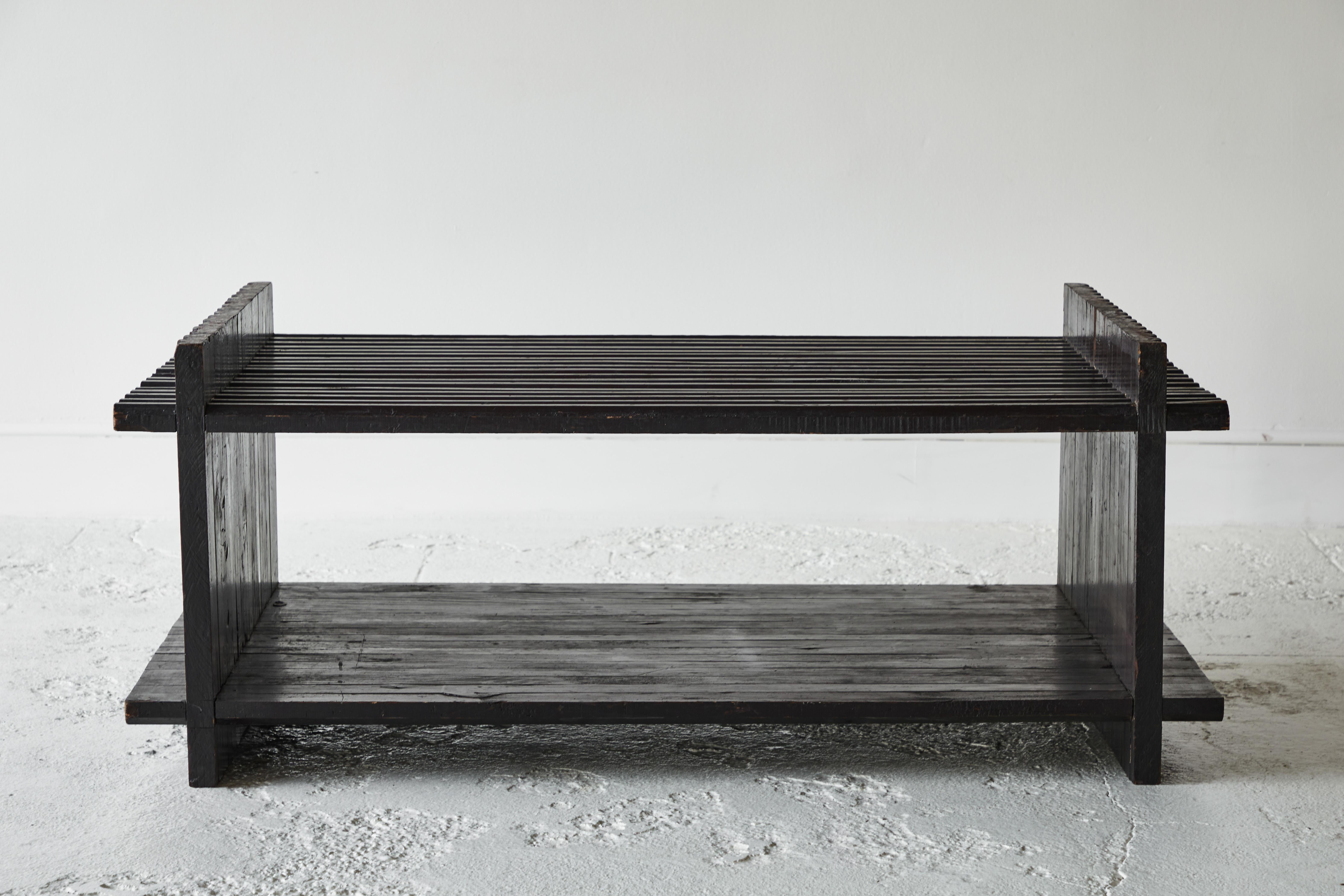 Black painted slatted cocktail table with grooved sides and overlapping corners.