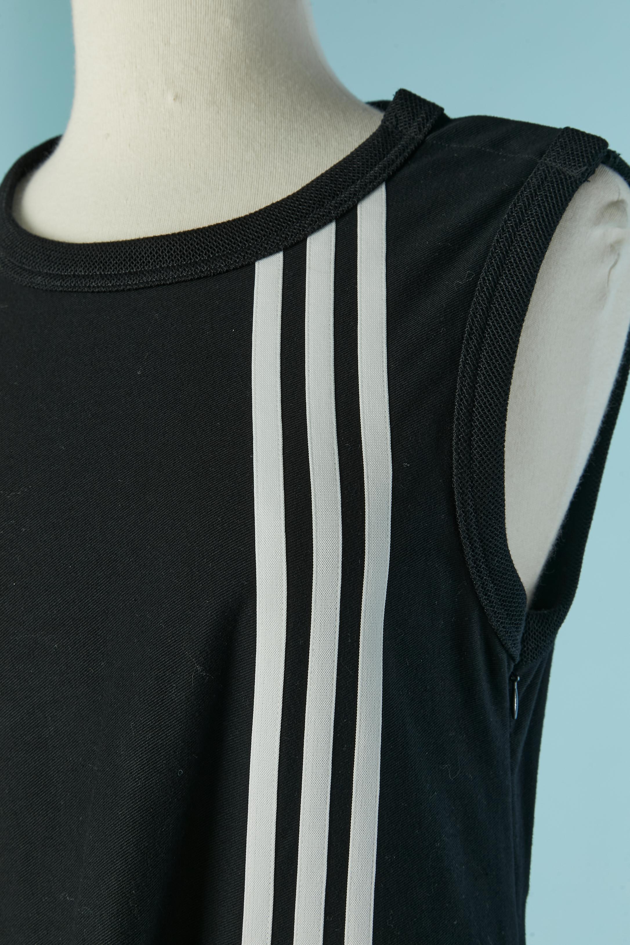 Schwarzer ärmelloser Baumwollpullover mit weißer Baumwollbandstreifen-Applikation. Druckknopfverschluss an der linken Schulter. Reißverschluss und Haken-Ösen-Verschluss auf der linken Seite. 
SIZE XS auf dem Etikett, passt aber wohl eher M 