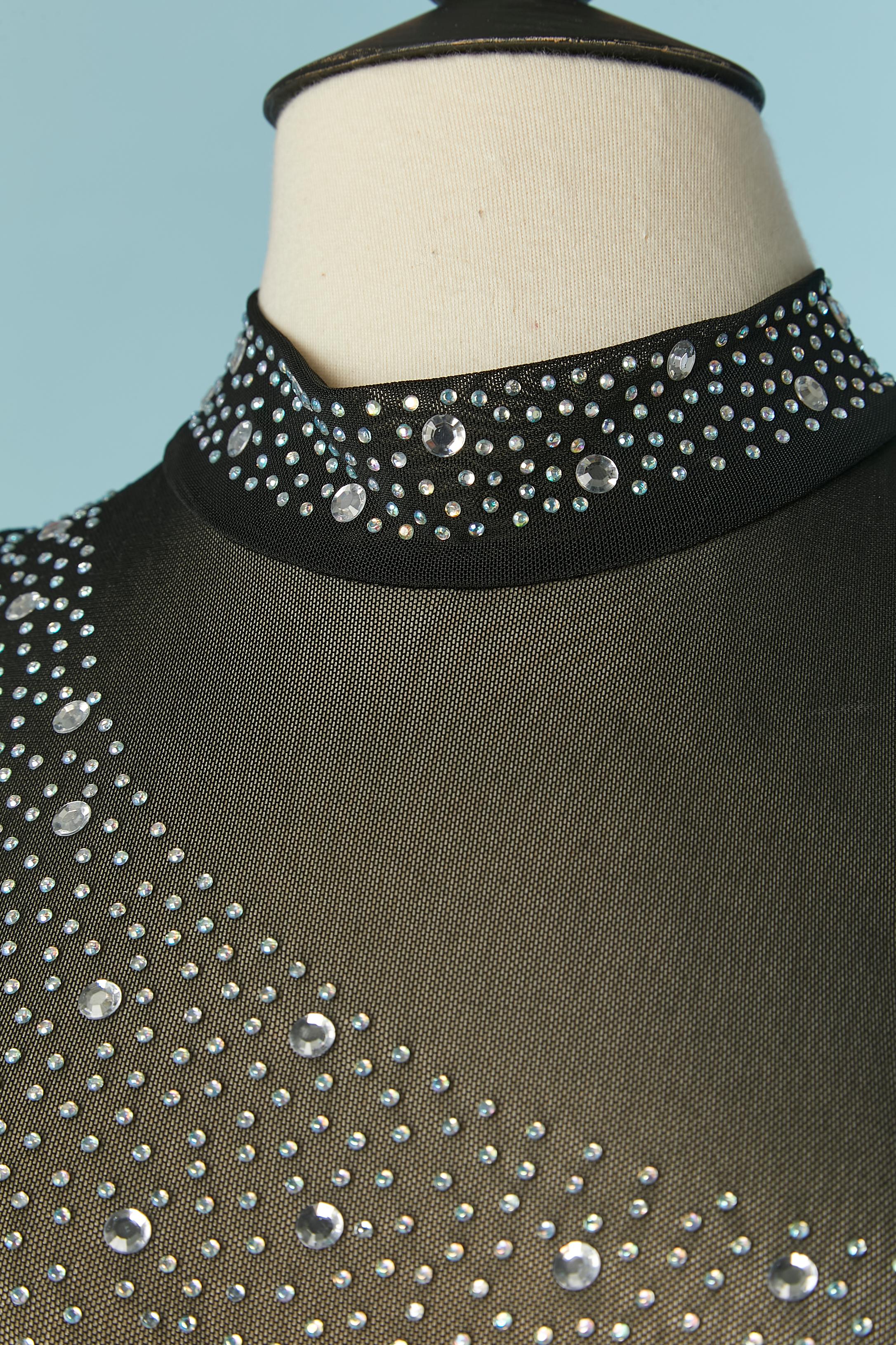 Tuta nera senza maniche in tulle elasticizzato, lycra e strass. 
Composizione della Fabrice: 95% poliestere, 5% spandex 
Chiusura con zip al centro della schiena. 
La taglia S sull'etichetta, ma la taglia è anche M. 