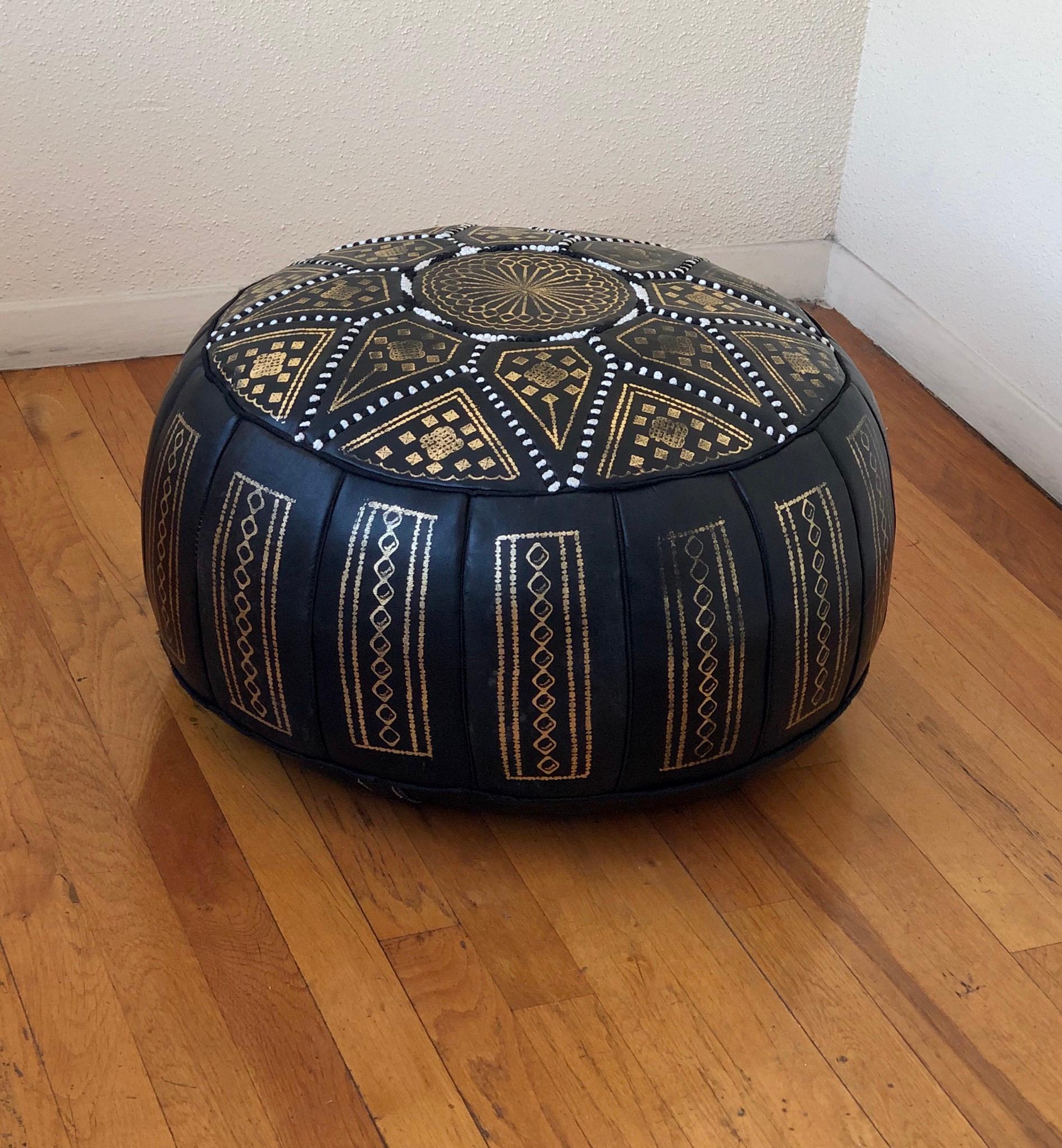 A beautiful great quality soft leather ottoman in black and gold motifs, nice quality light use hard to find color combo.