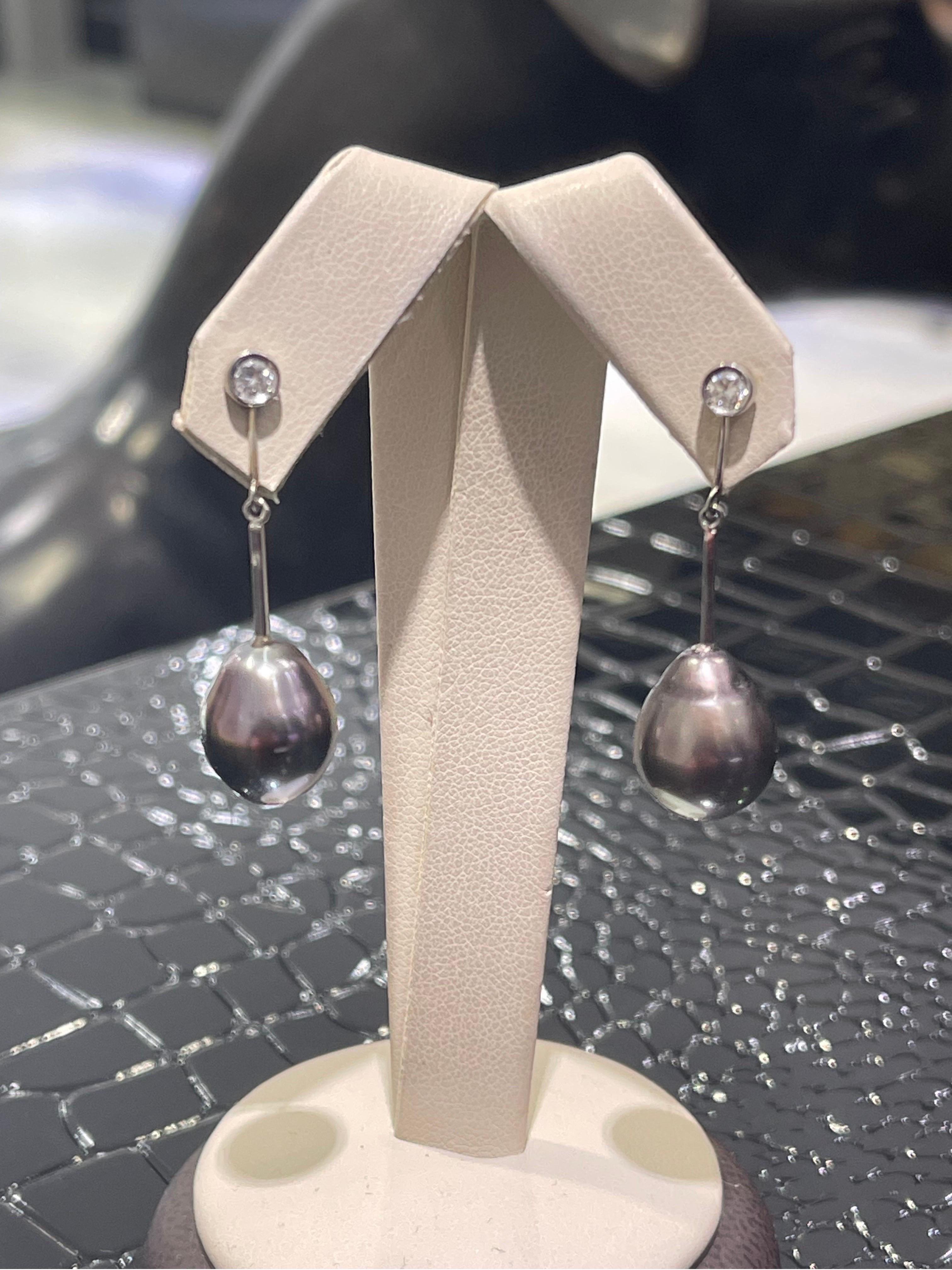 Black South Sea Pearl & Diamond Earrings In 14k White Gold.

Pears are in drop shape, approximately 13mm (length), 11mm (width).

Hanging length of the earrings is 1.5”.