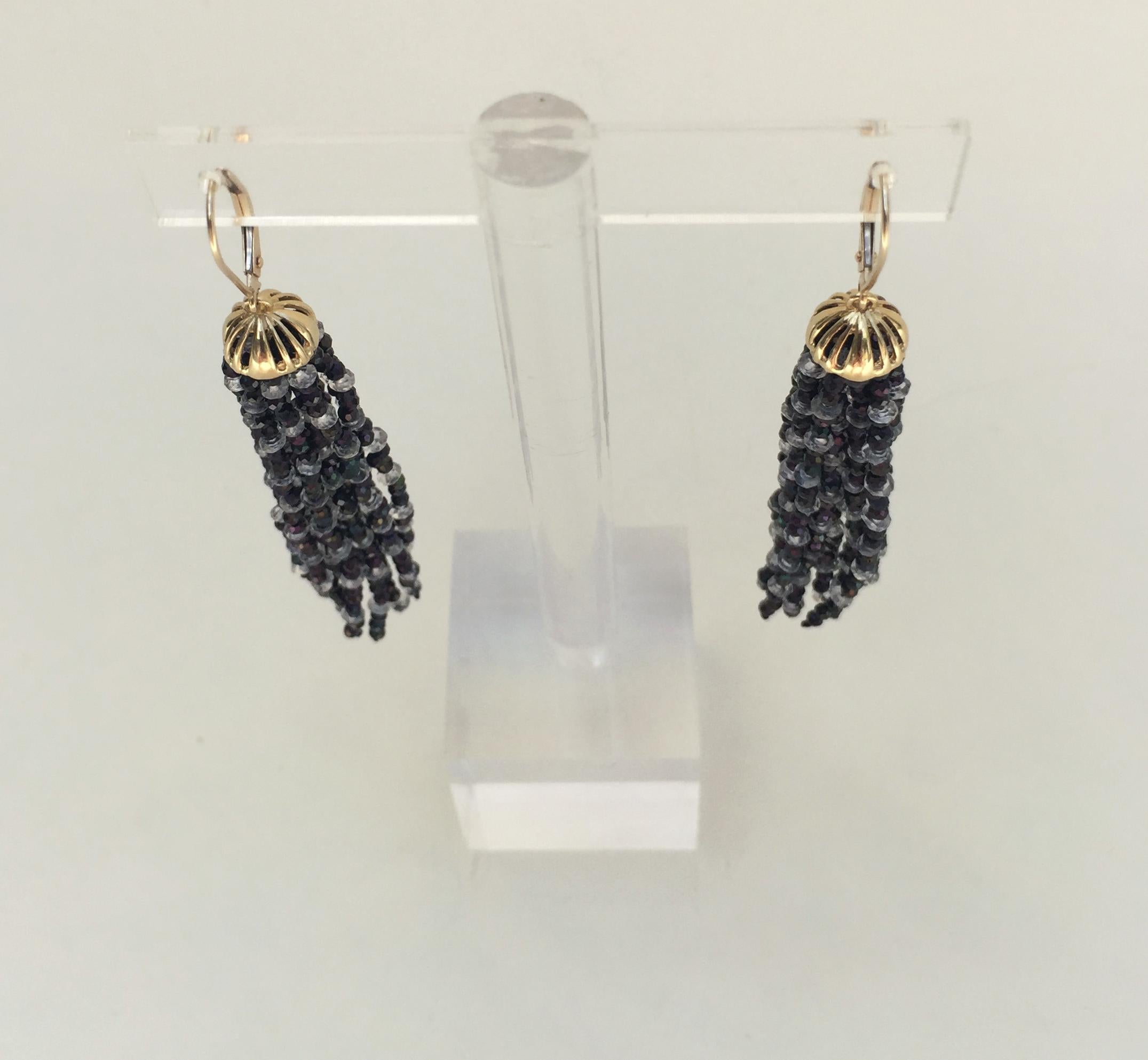 The black spinel and white topaz tassel earrings with 14k yellow gold lever backs and cup are striking and dazzling. With the black spinel and white topaz faceted beaded pattern, the earrings become a sparkling take on the Art Deco inspired classic