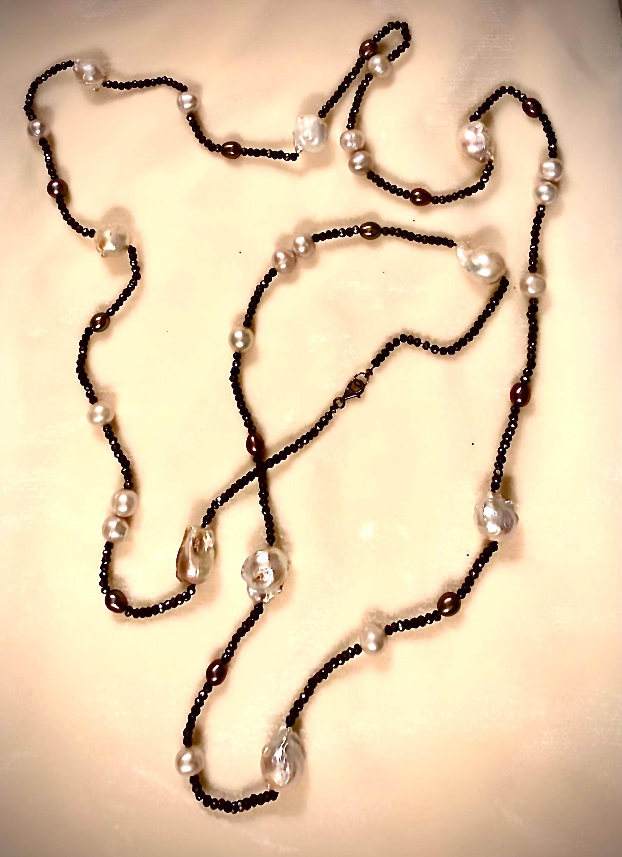 Very long and striking necklace of faceted black spinels with cultured black oval pearls, fresh white cercle off round pearls and large freshwater white baroque pearls.

There is a small black patinated sterling silver lobster clasp which is
