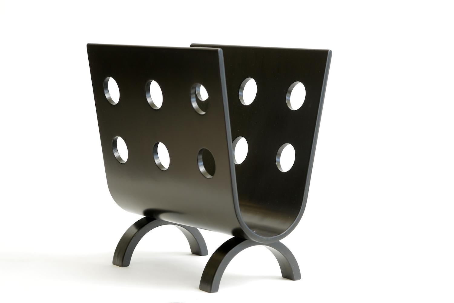This fabulous and very uncommon Mid-Century Modern bentwood magazine stand or rack is from the 1950s. It is stained black from how it was acquired. The cutout holes are so very modern now as they were then. It is a beauty and winner on all levels.