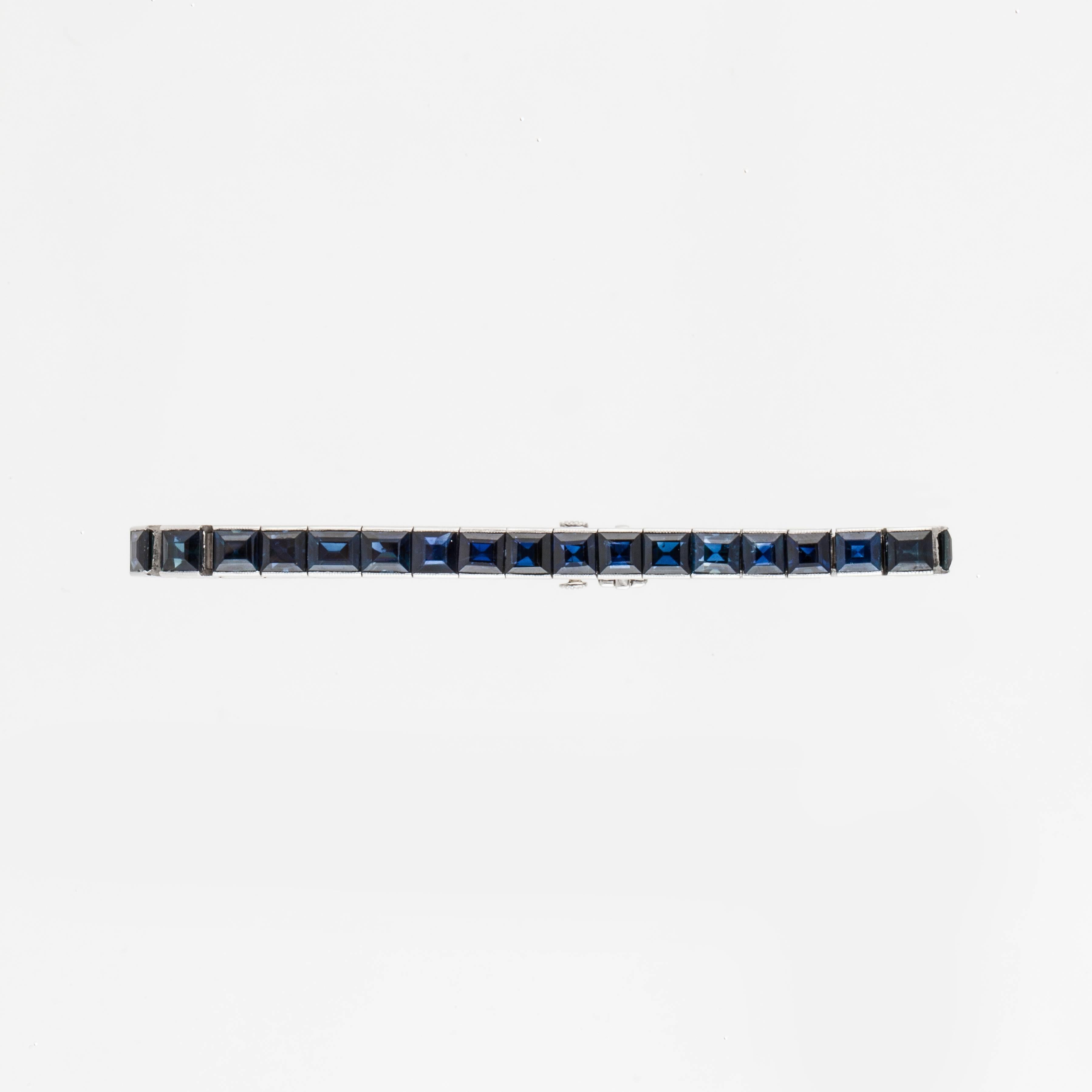Black Starr & Frost platinum line bracelet featuring thirty-six (36) square-cut sapphires that total 27 carats.  There is beautiful engraving along the outside edges.  Bracelet has a tongue closure with safety and measures 6.5 inches in length and
