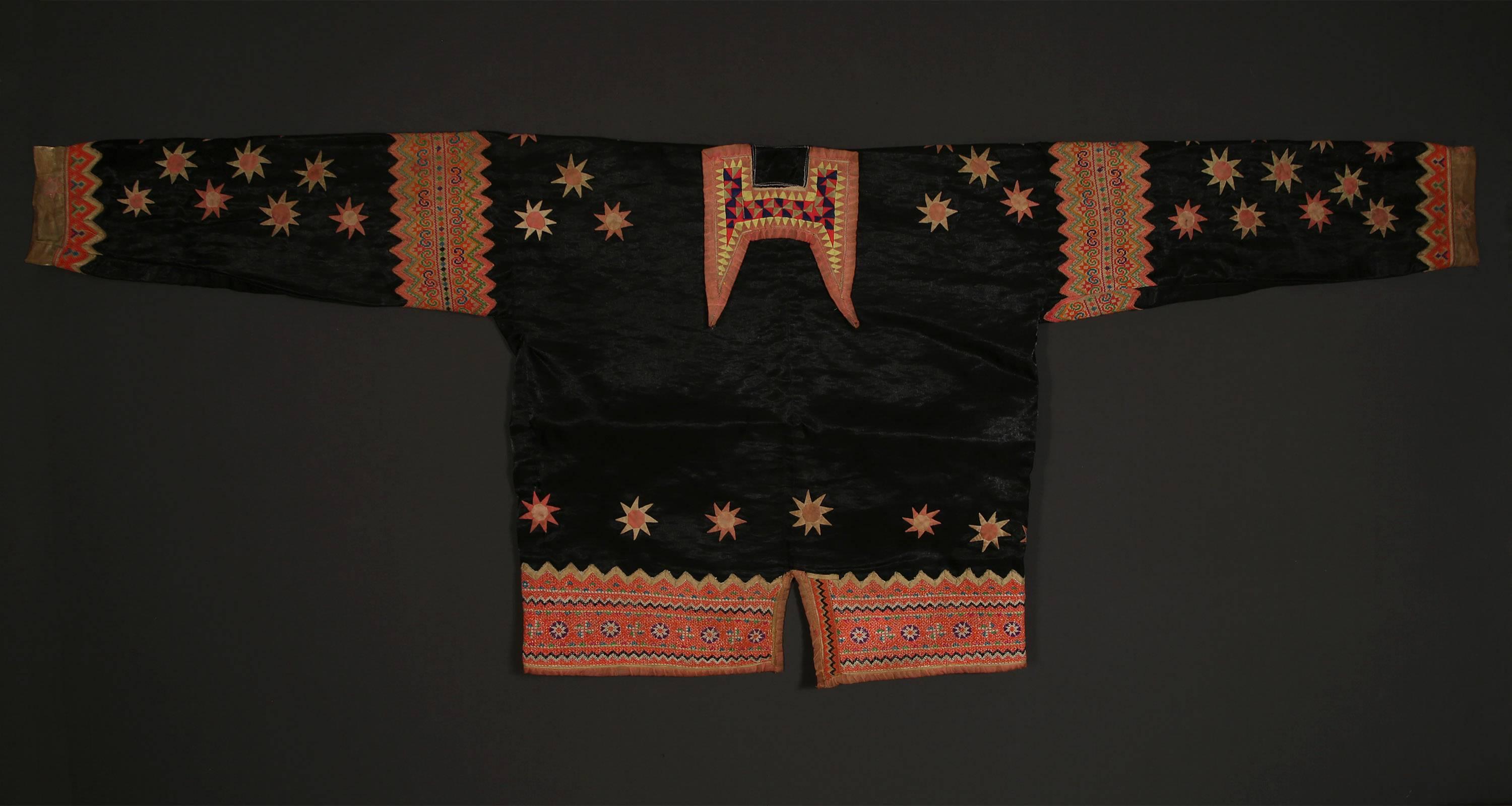 Schwarze Sternjacke des Hmong-Volkes in Laos, Anfang des 20.
Eine kühn verzierte Jacke mit leuchtenden Sternapplikationen und komplizierten Kreuzstichstickereien ist ein einzigartiges Beispiel für die traditionelle Trachtenherstellung des
