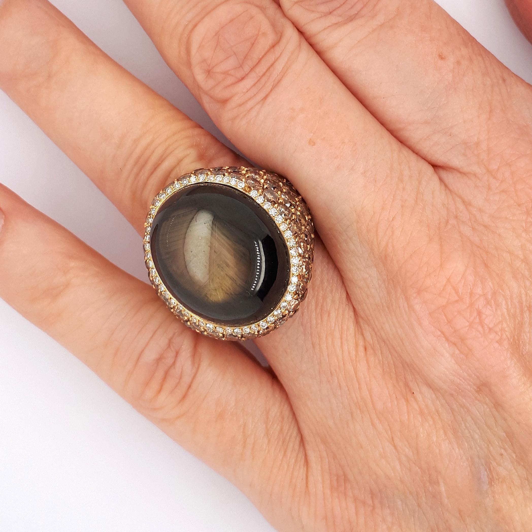 Ein Ring aus schwarzem Sternsaphir und braunen Diamanten, mit einem ovalen schwarzen Sternsaphir im Cabochon-Schliff mit einem geschätzten Gewicht von 53,86 ct und einer Einfassung aus Diamanten im Acht-Schliff  weiße Diamanten, mit braunen