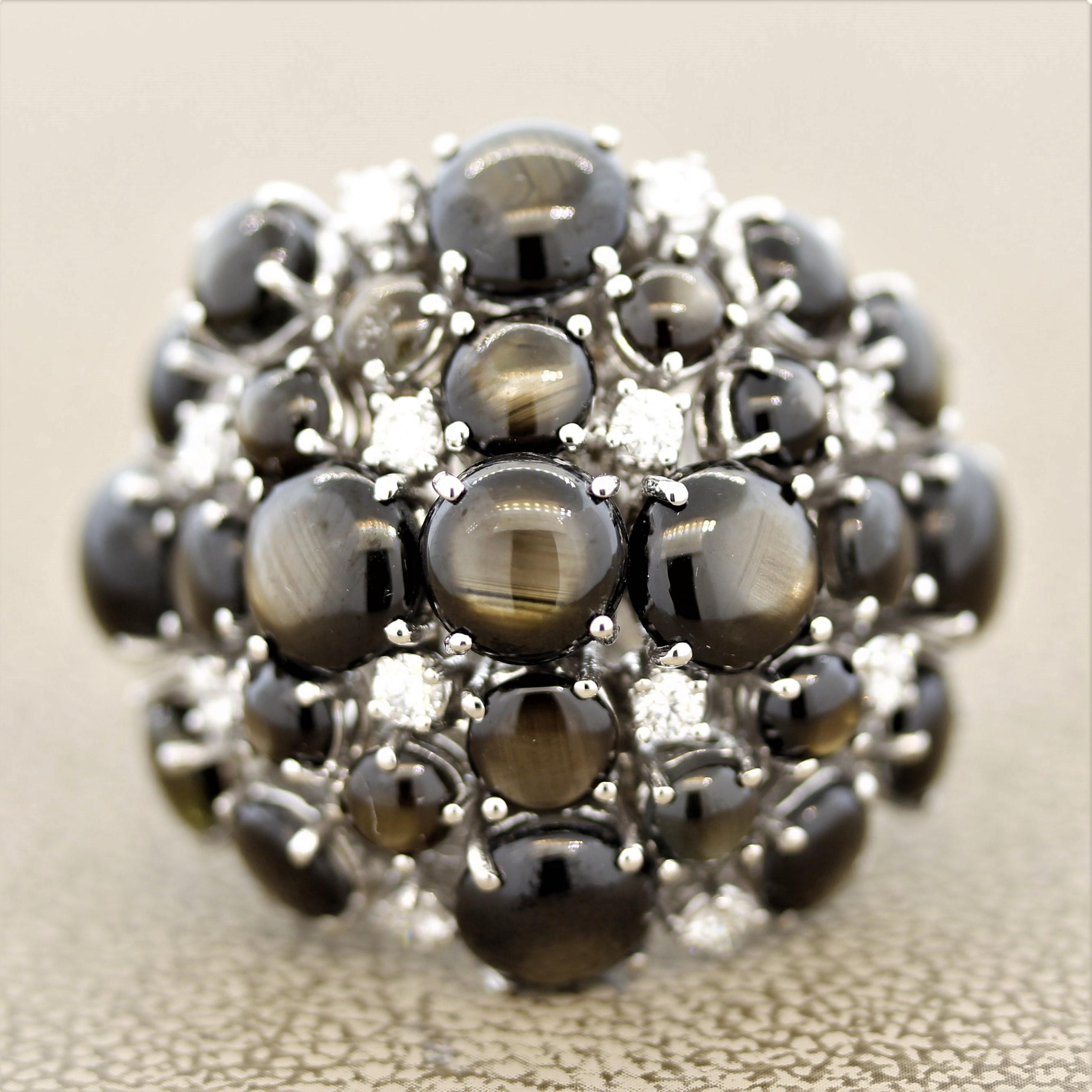 An impressive and stylish cocktail ring featuring 22.75 carats of black star sapphires! Each sapphire has a strong fine quality star as light hits the stones, which is known as asterism. Within the cluster of star sapphires are 0.64 carats of round