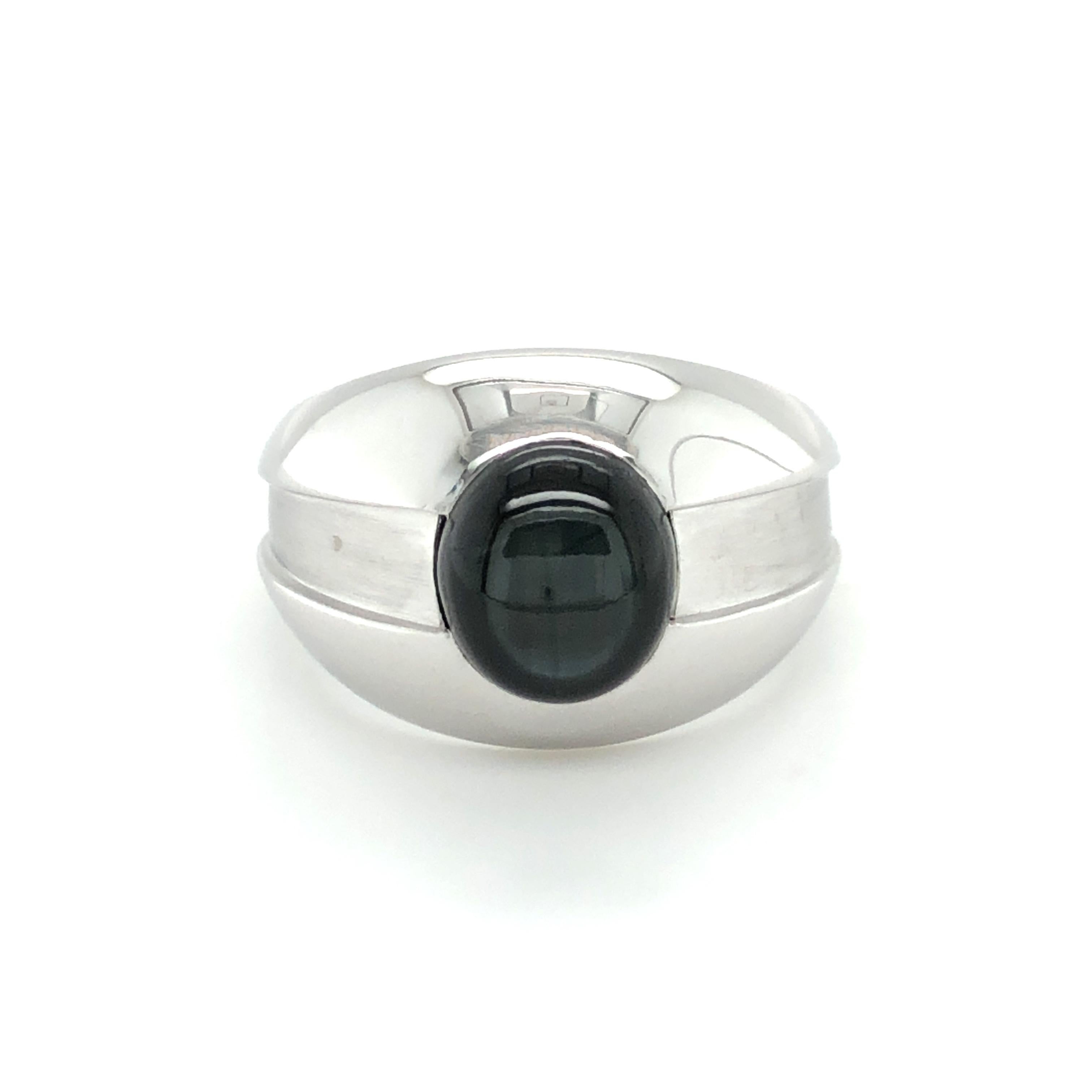 This elegant ring in 18 karat white gold by reknowned Swiss jeweller Gübelin is set with a cabochon-cut black star sapphire of 7.25 carats. The beautiful star sapphire captivates with a light bluish shimmer and a six-pointed star that gently
