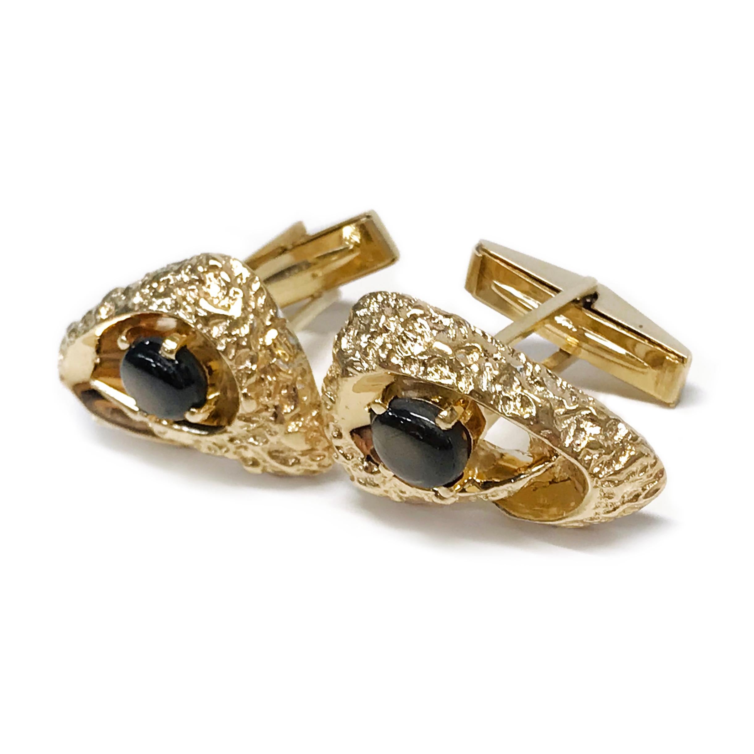 Black Star Sapphire Triangle-Shaped Swoosh Gold Nugget Cufflinks. The cufflinks are triangle-shaped with rounded edges and a 6.5x7.4mm black star sapphire prong-set at in the center. The cufflinks are gold nugget style with the post and backings in