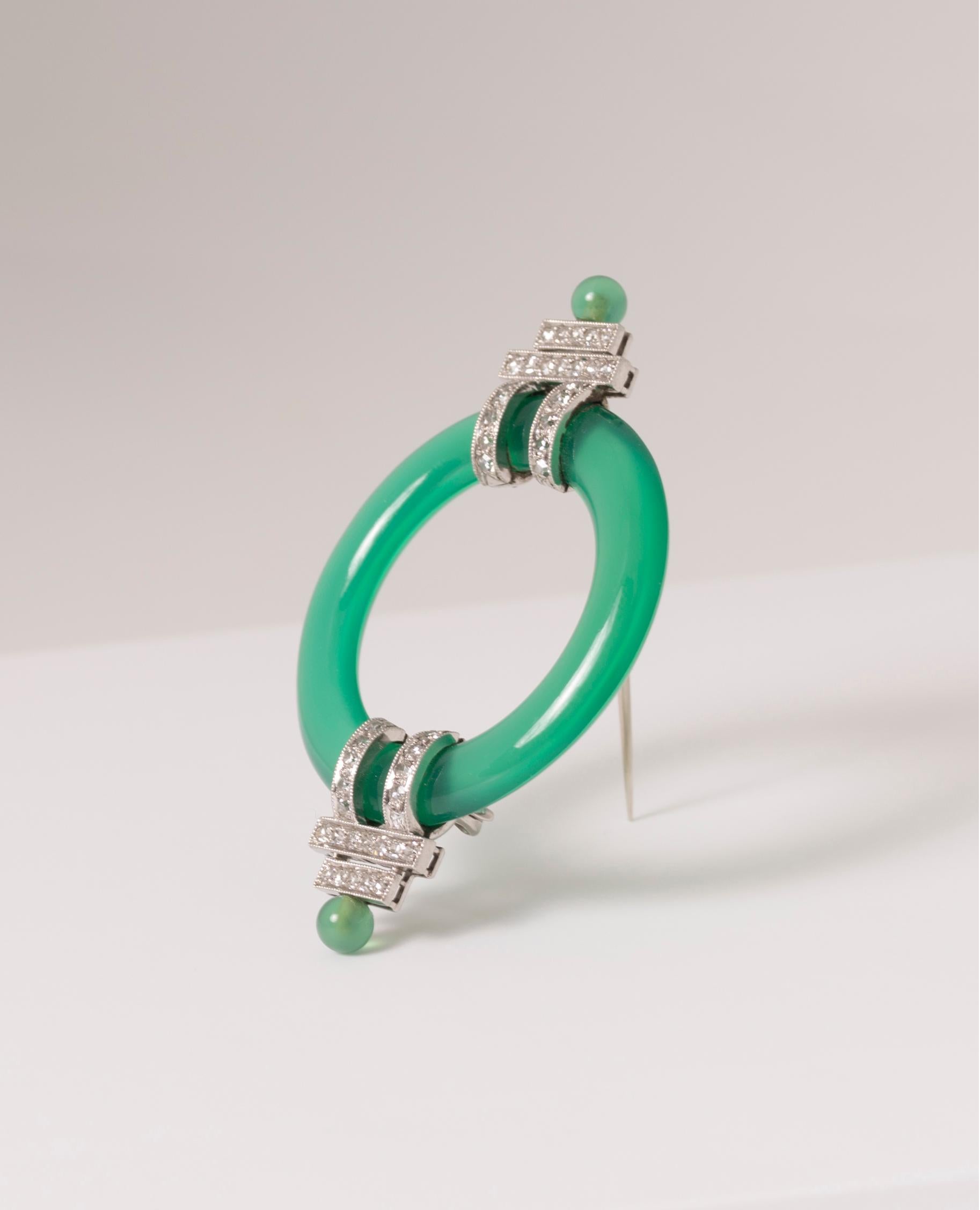 Black Starr & Frost
Ring Brooch, Circa 1925.
The carved chrysoprase ring with single-cut diamond (approx. 0.45 Carats) millegrained platinum straps and terminals
Signed B.S & F
 
The geometric shape associated with the strong green color of the ring
