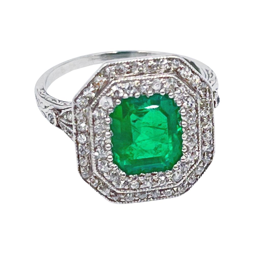 Art Deco period ring Handmade in platinum with beautiful detailed engraving. Set with a central, rectangular, step-cut, natural Colombian emerald measuring approximately L.9.50 x W.7.20 x D.5.23mm and weighing approximately 2.43 carats.  American