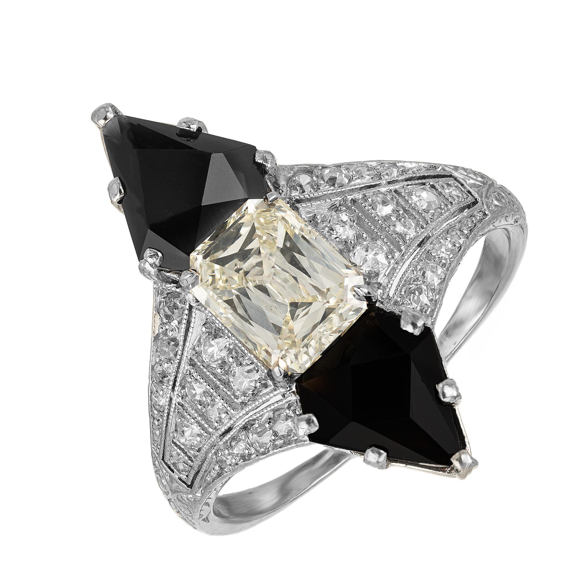 Unique 1930's Art Deco Black Star & Frost onyx and diamond cocktail ring. This stunning gem features two Calibré cut black Onyx with an emerald step cut 1.03ct center diamond mounted in a filigree platinum setting with 28 round cut accent diamonds.