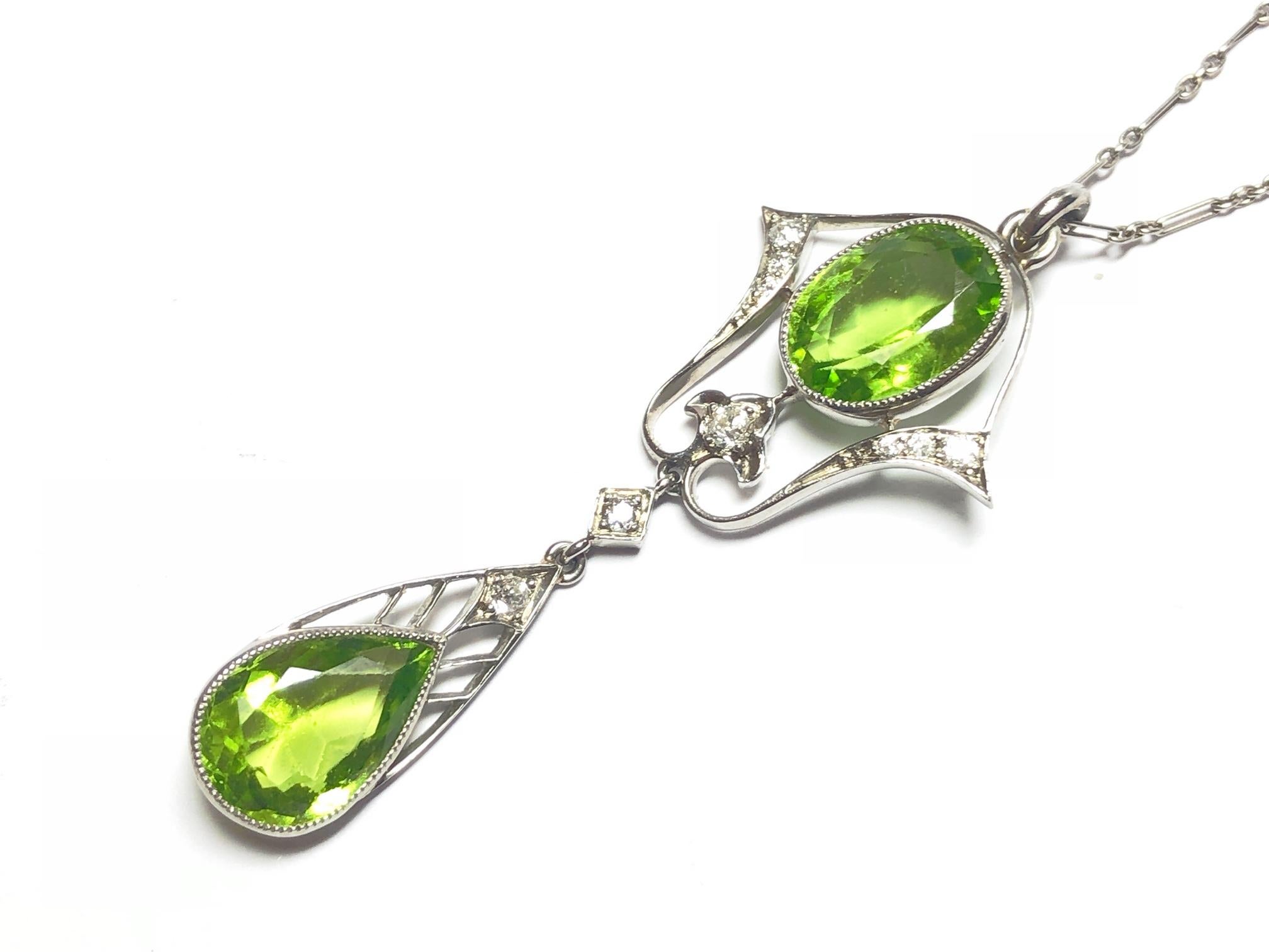 A Black Starr & Frost peridot and diamond Lavalier style pendant, set with old-cut diamonds, with an oval faceted peridot, with an estimated total weight of 3.61ct and a pear shape peridot, with an estimated total weight of 3.44ct, hanging from a