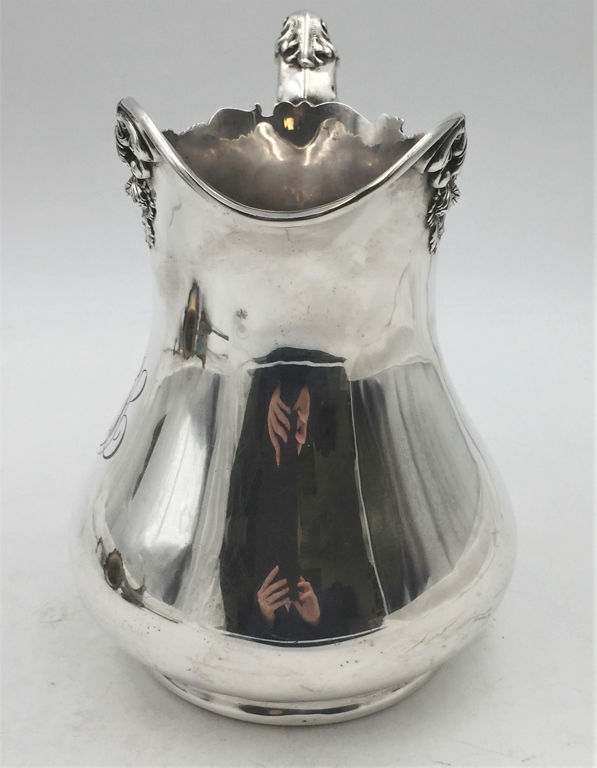 Early 20th century, Black, Starr & Frost sterling silver pitcher in exquisite Art Nouveau style with dimensional flowers applied around the rim. It measures 8 3/4'' in height by 9'' from handle to spout by 6 1/2'' in depth, weighs 22.9 ozt, shows