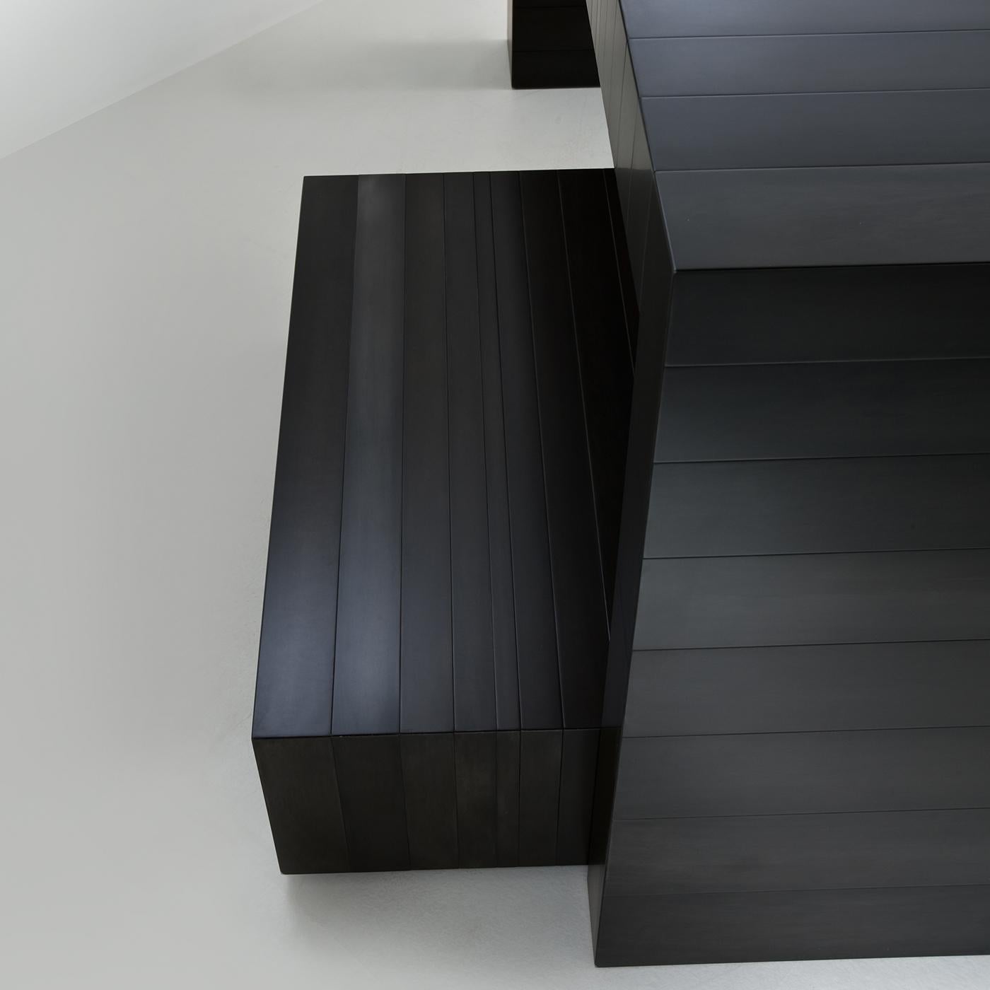 Simple lines run vertically through the top and supporting sides of this solid, modern console table, giving it movement and a modern look. Both the sides and the top of this piece are entirely finished in black metal, and various finishes are