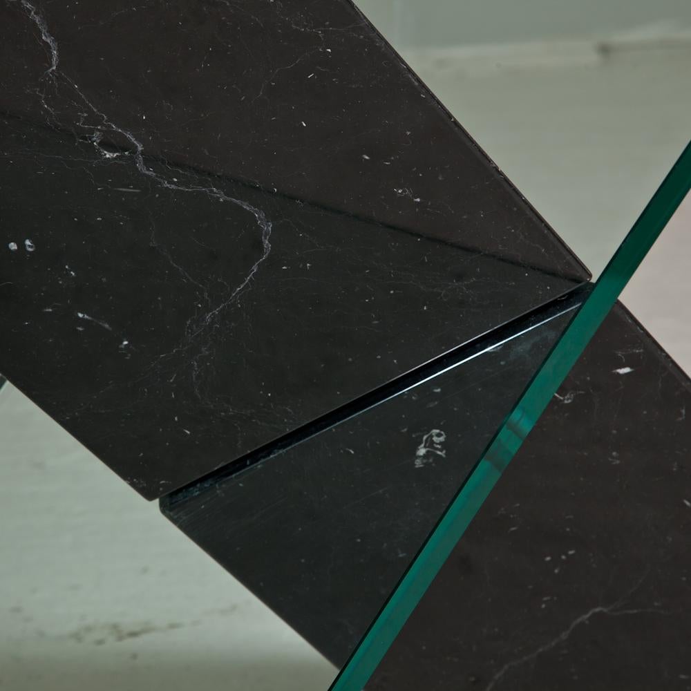 A black stone with glass cutting through the centre to create a cross, and complete with a glass top, designed by Reflex for Roche Bobois 1980s.

Image is slightly inaccurate as there is now a steel wrap around the base of the marble.
