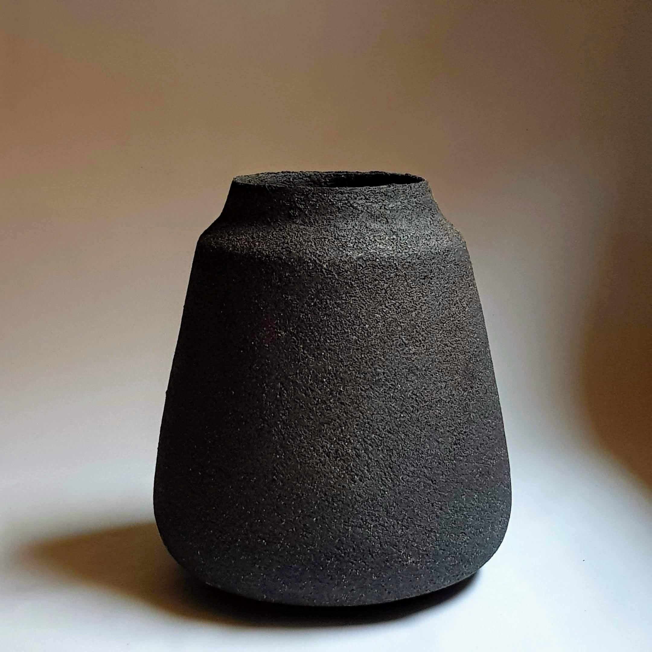 Black Stoneware Kados Vase by Elena Vasilantonaki
Unique
Dimensions: ⌀ 30 x H 25 cm (Dimensions may vary)
Materials: Stoneware
Available finishes: Black, White, Grey, Brown, Red, White Patina

Growing up in Greece I was surrounded by pottery forms