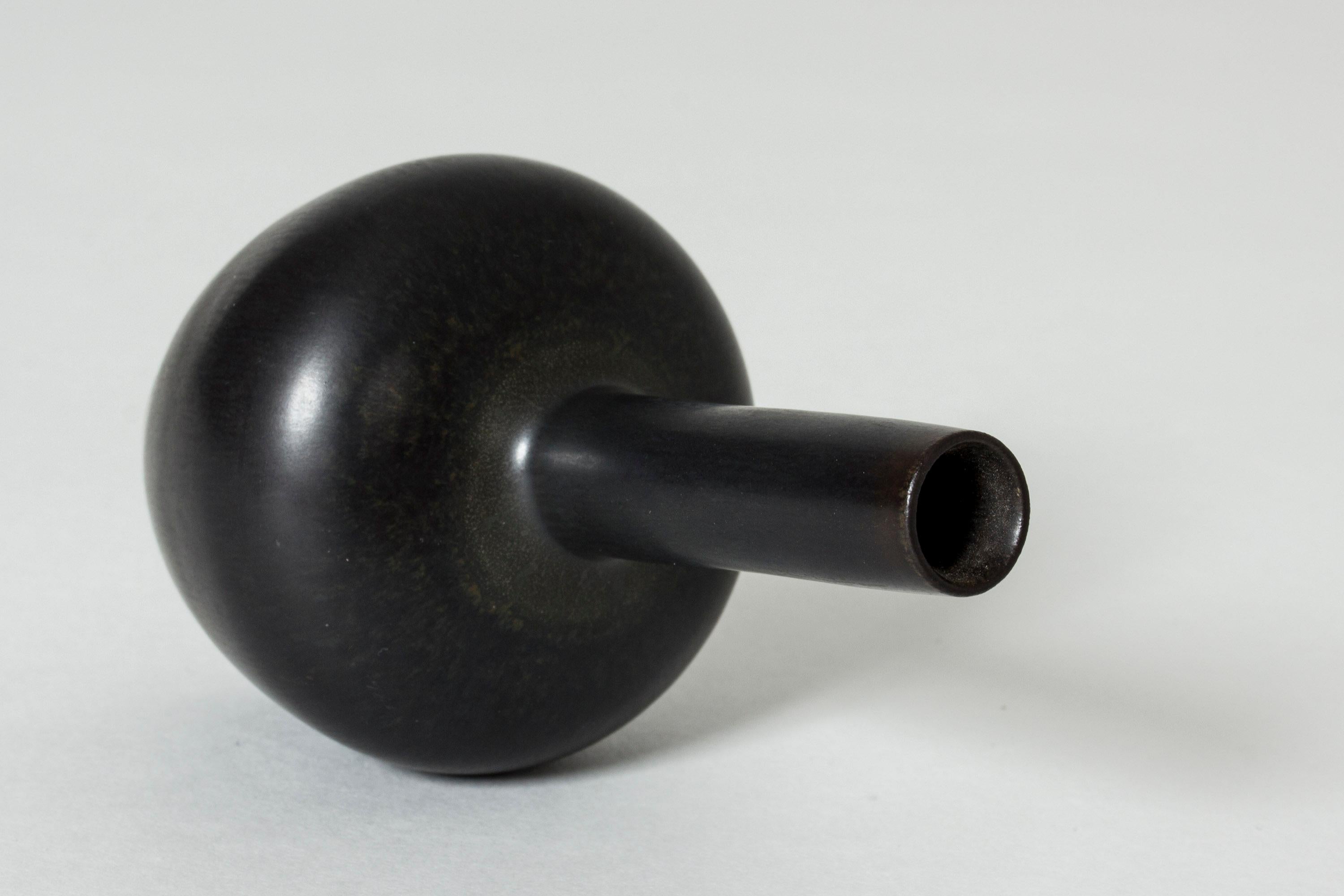 Cool, small stoneware vase by Carl-Harry Stålhane. Straight, long neck extending from the plump body. Smooth black glaze.